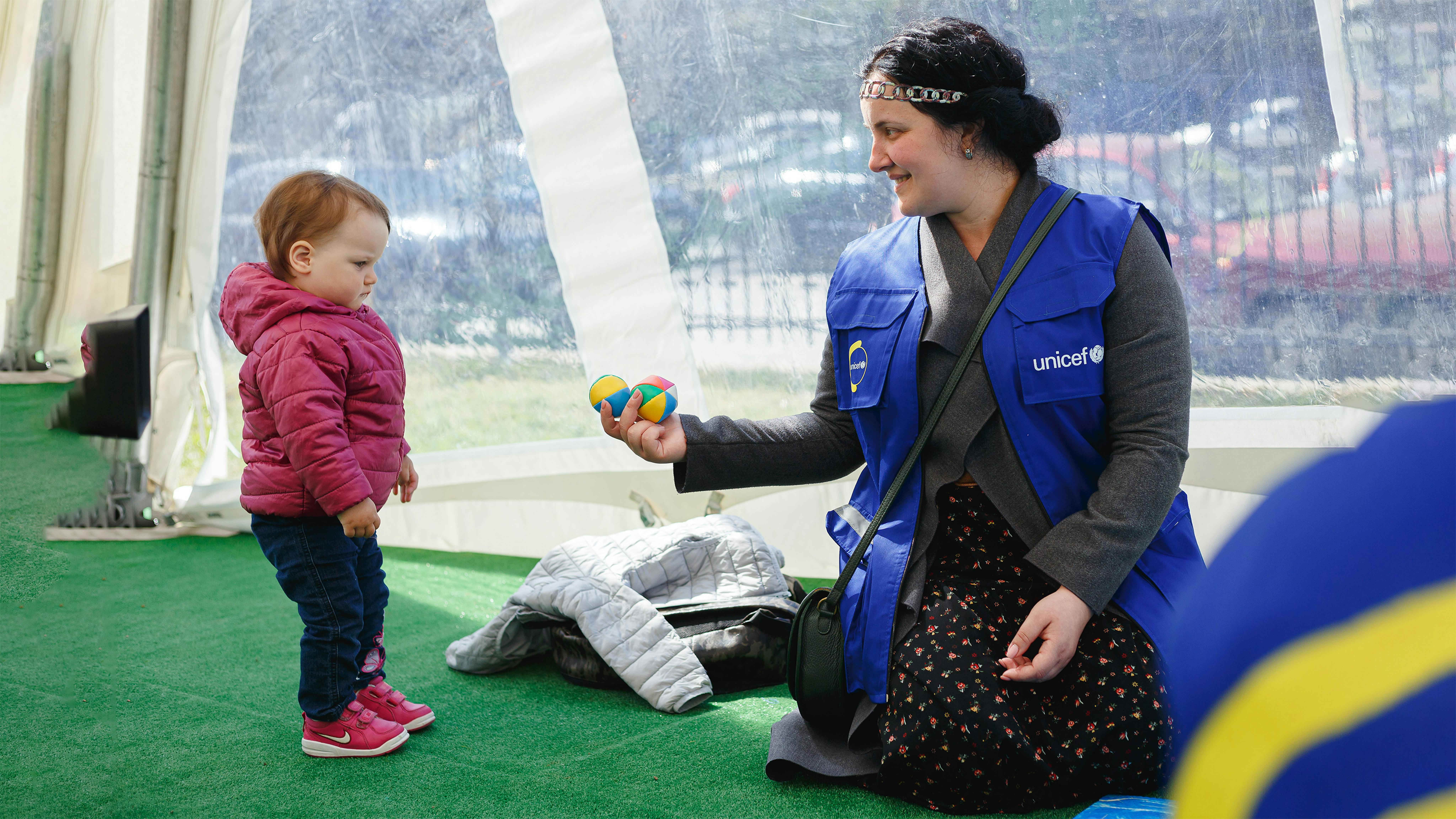 Un'operatrice dell'UNICEF con un bambino al Mobile Child Spot di Uzhhorod.