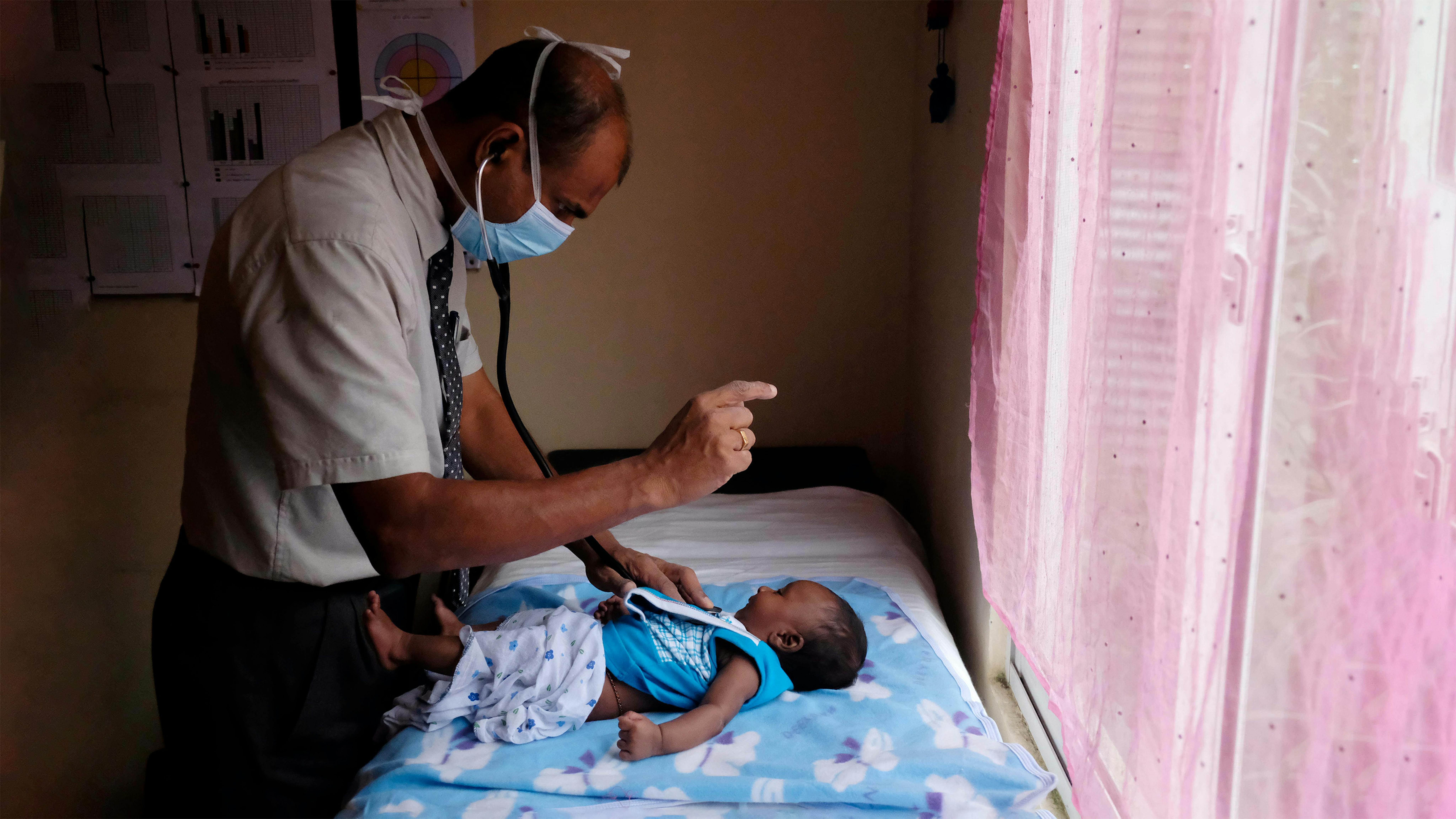 Sri-Lanka - Dr.Ruwan Jayasingha, MOH che conduce il controllo sanitario di una madre durante la clinica sanitaria