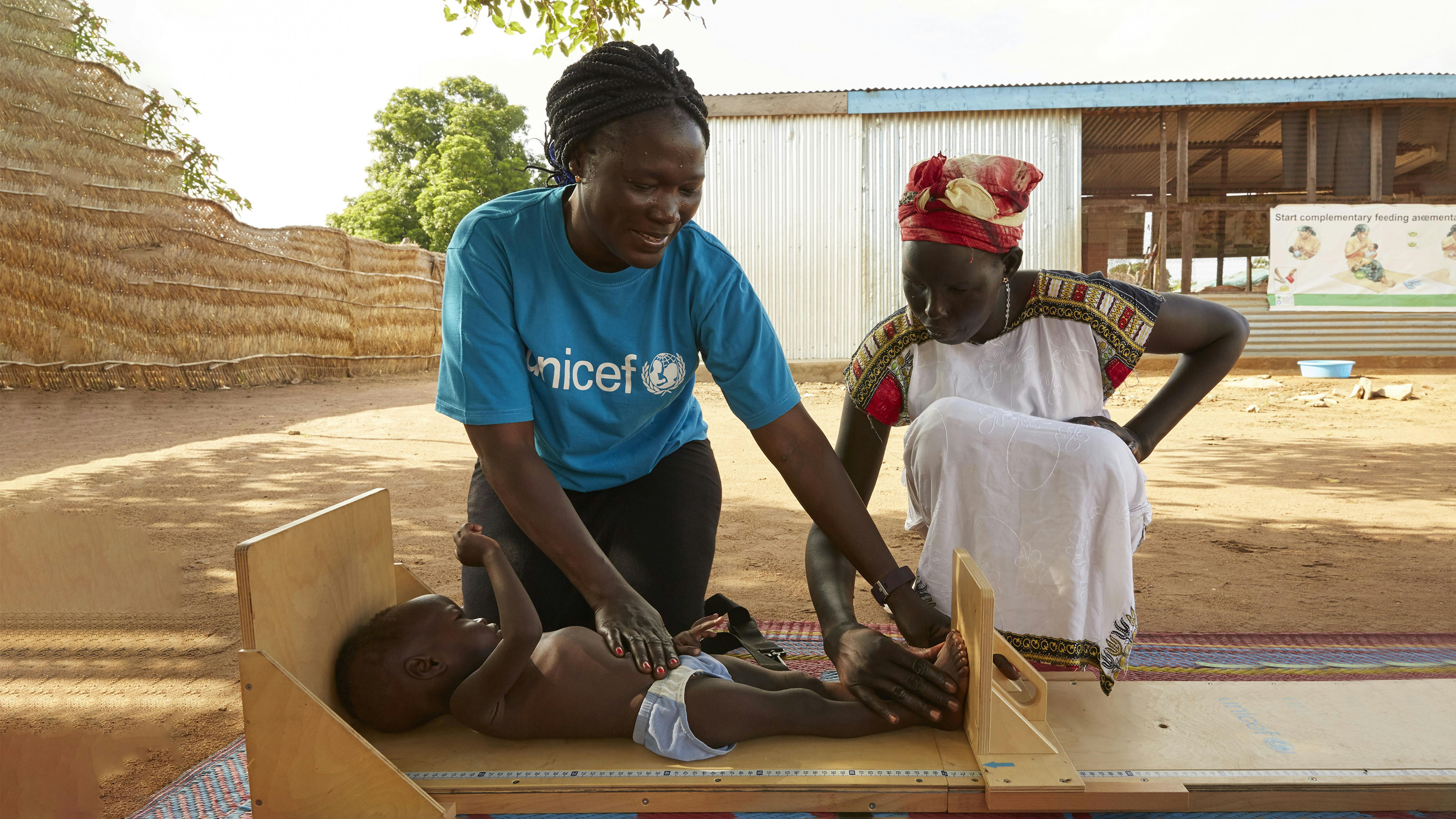 Sud Sudan La nutrizionista dell'UNICEF Jesca Wude Murye sta misurando la lunghezza di Adut con l'aiuto della madre  Angelina.