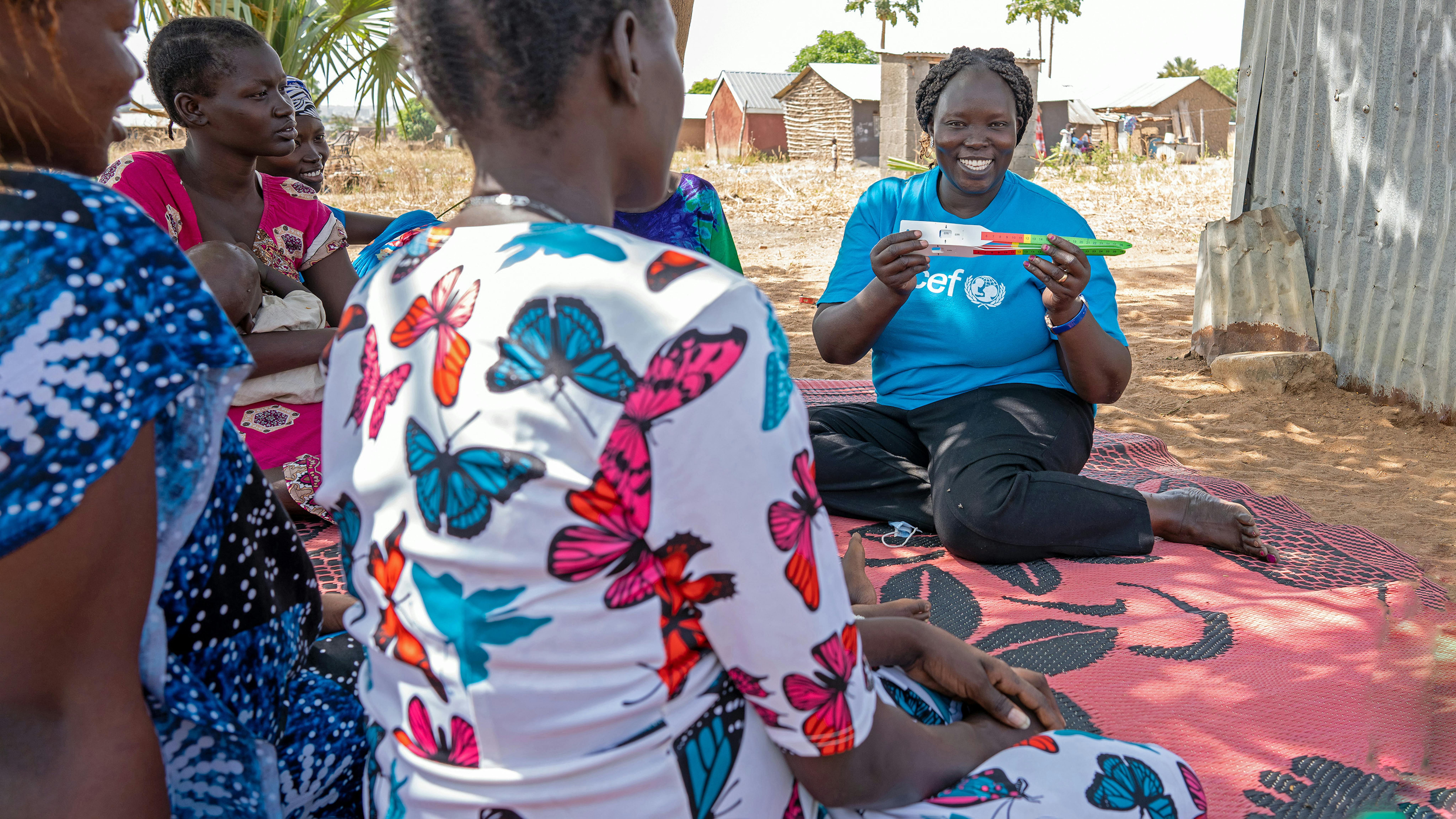 Sud Sudan - Mary Achii, membro del team di nutrizione dell'UNICEF, mostra alle giovani madri come valutare la malnutrizione dei propri figli utilizzando il MUAC,  uno strumento antropomorfico