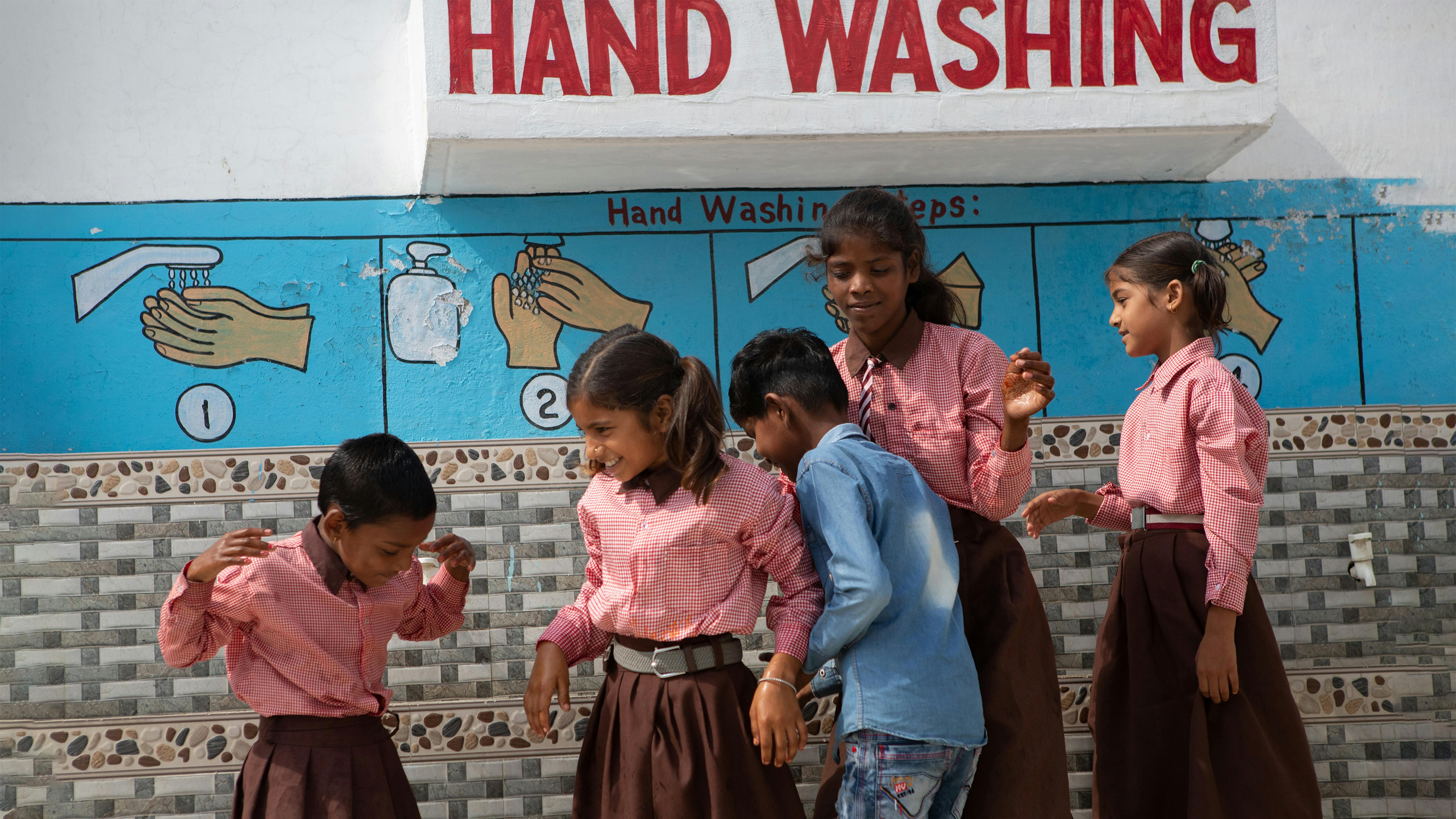 India - Studenti  utilizzano l'area di lavaggio delle mani presso la Rawatpar Amethia Composite School di Laar