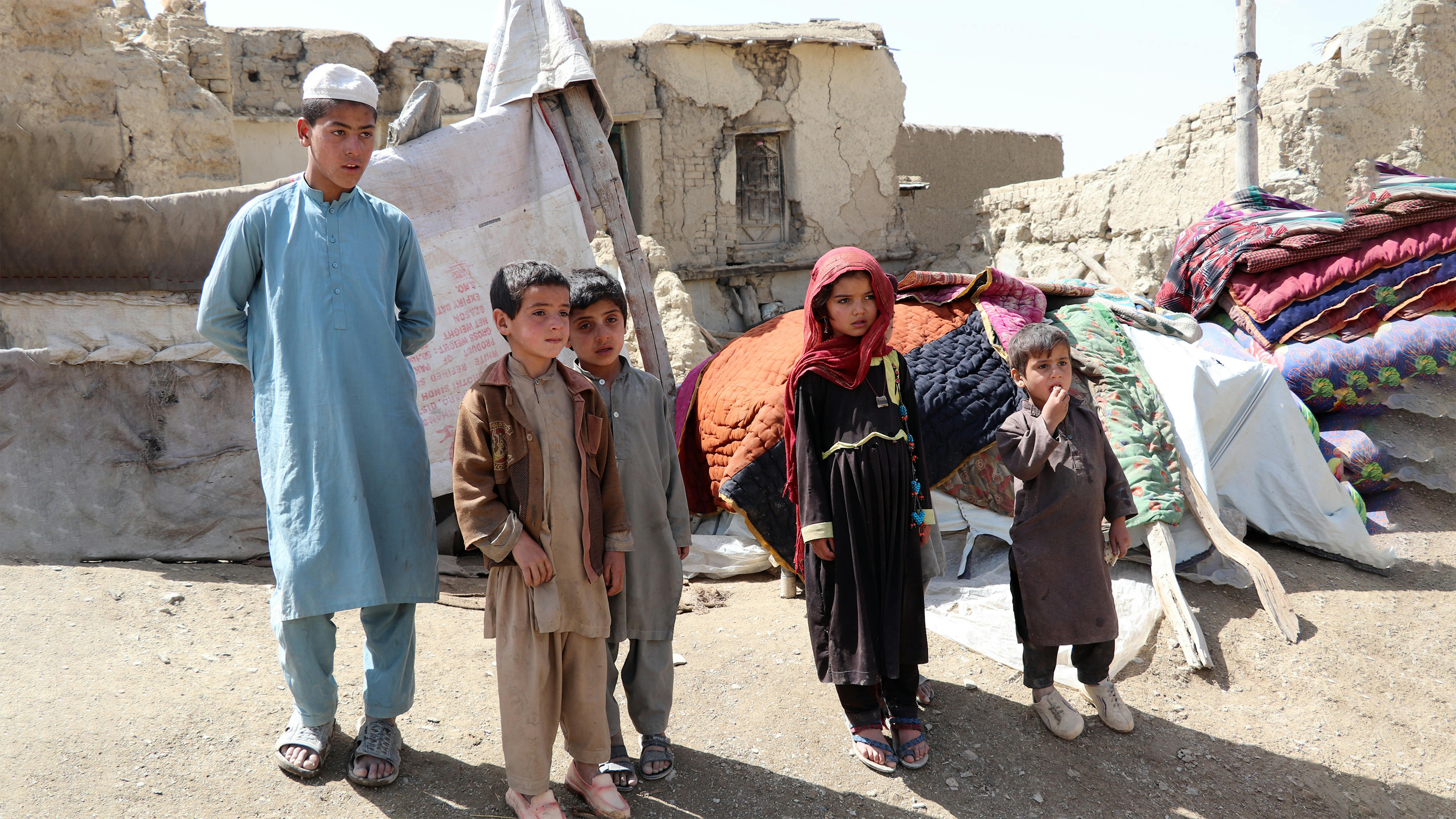 Afghanistan, Dopo il devastante terremoto di magnitudo 5,9, Rahmatullah, 14 anni, Halim, 8, Nik Mohamad, 7, Jamila 7 e Ghafoor, 6, sono davanti alle macerie della loro casa nel villaggio di Gayan, provincia di Paktika,.