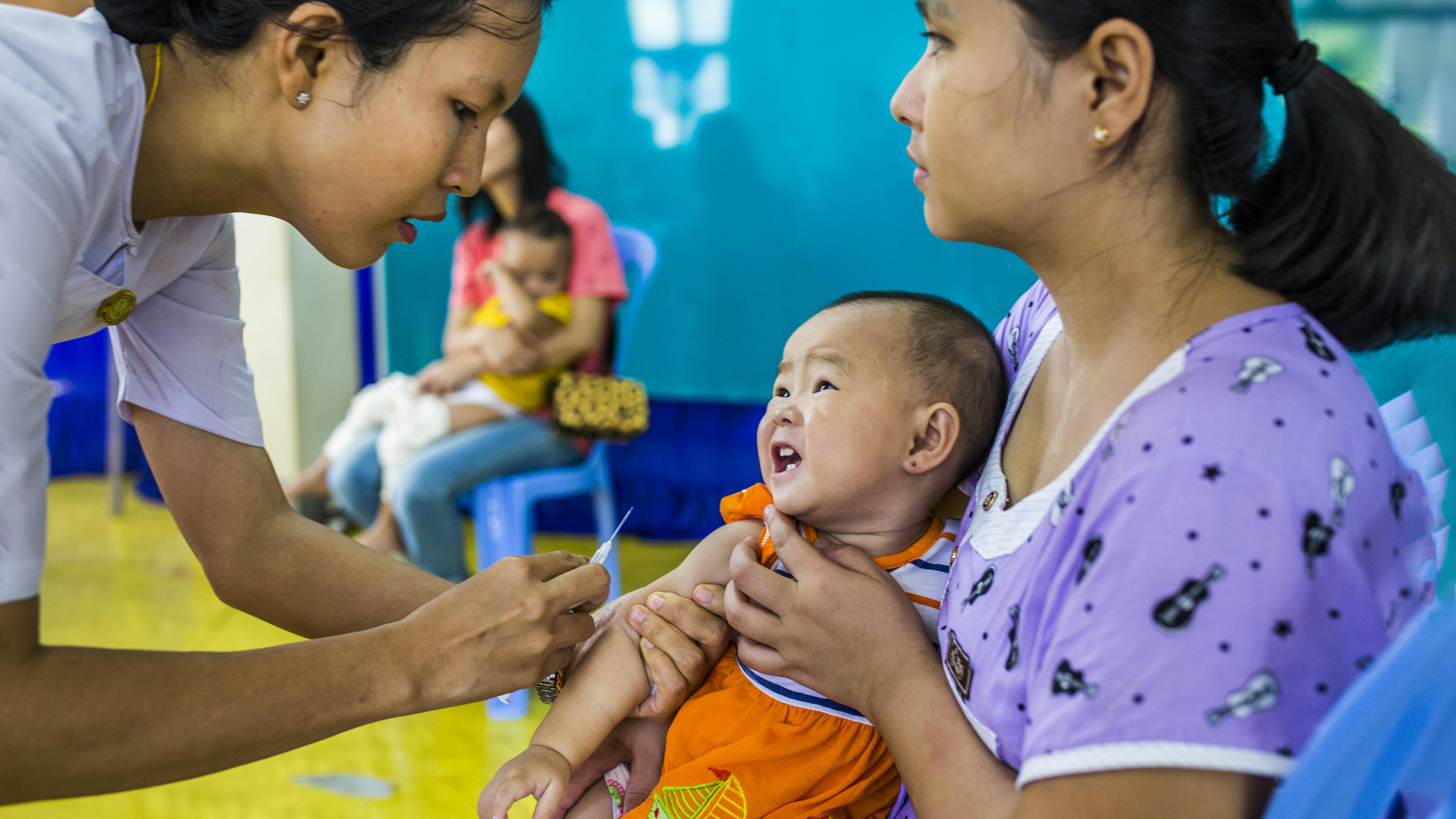 Myanmar - Una bambina reagisce quando le viene somministrata un'iniezione di vaccinazione da un operatore sanitario