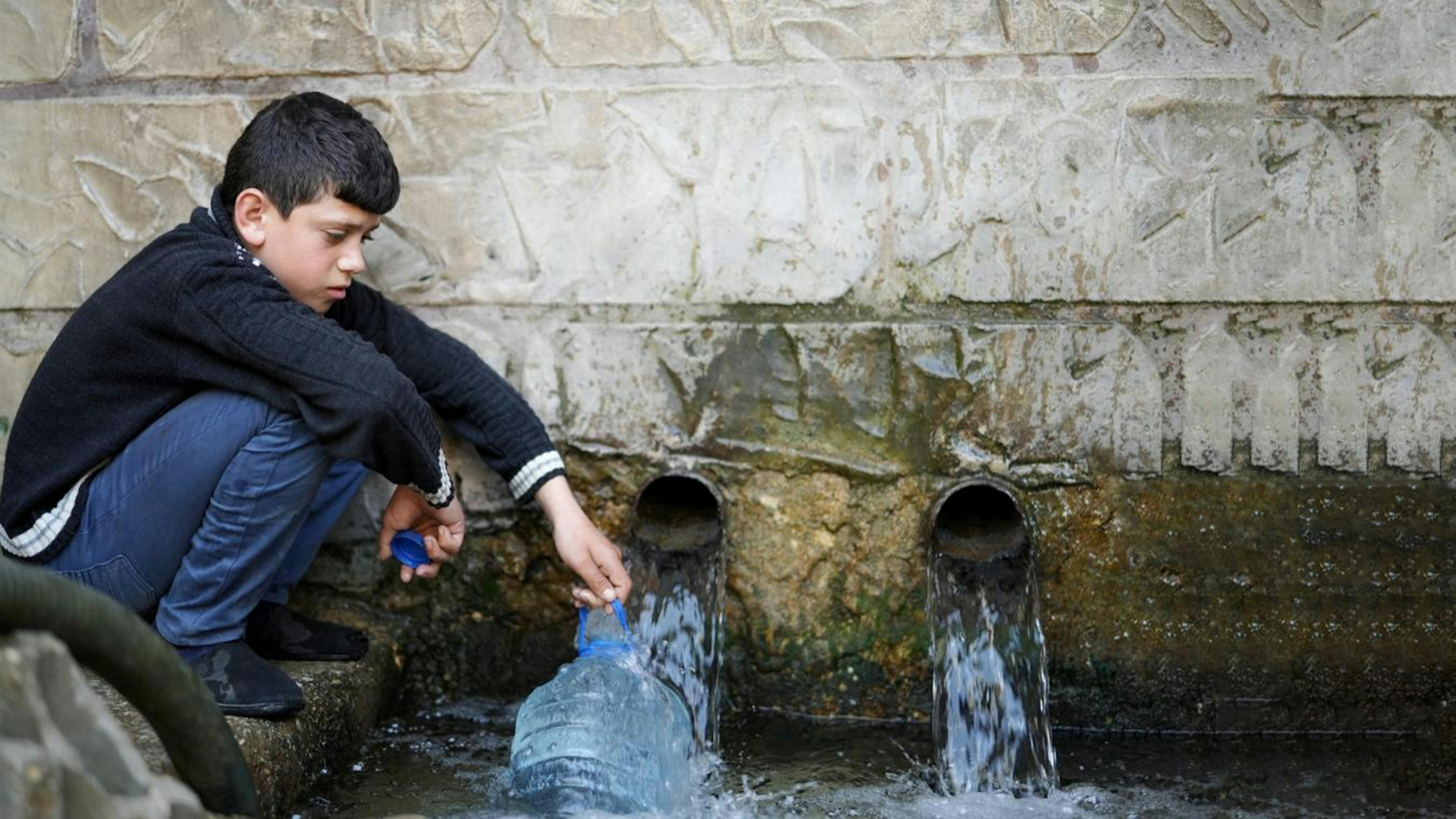 Per molti in Libano, l'unica fonte di acqua fresca e sicura rimane il pozzo del villaggio. Adham, 11 anni, riempie i contenitori  per la sua famiglia