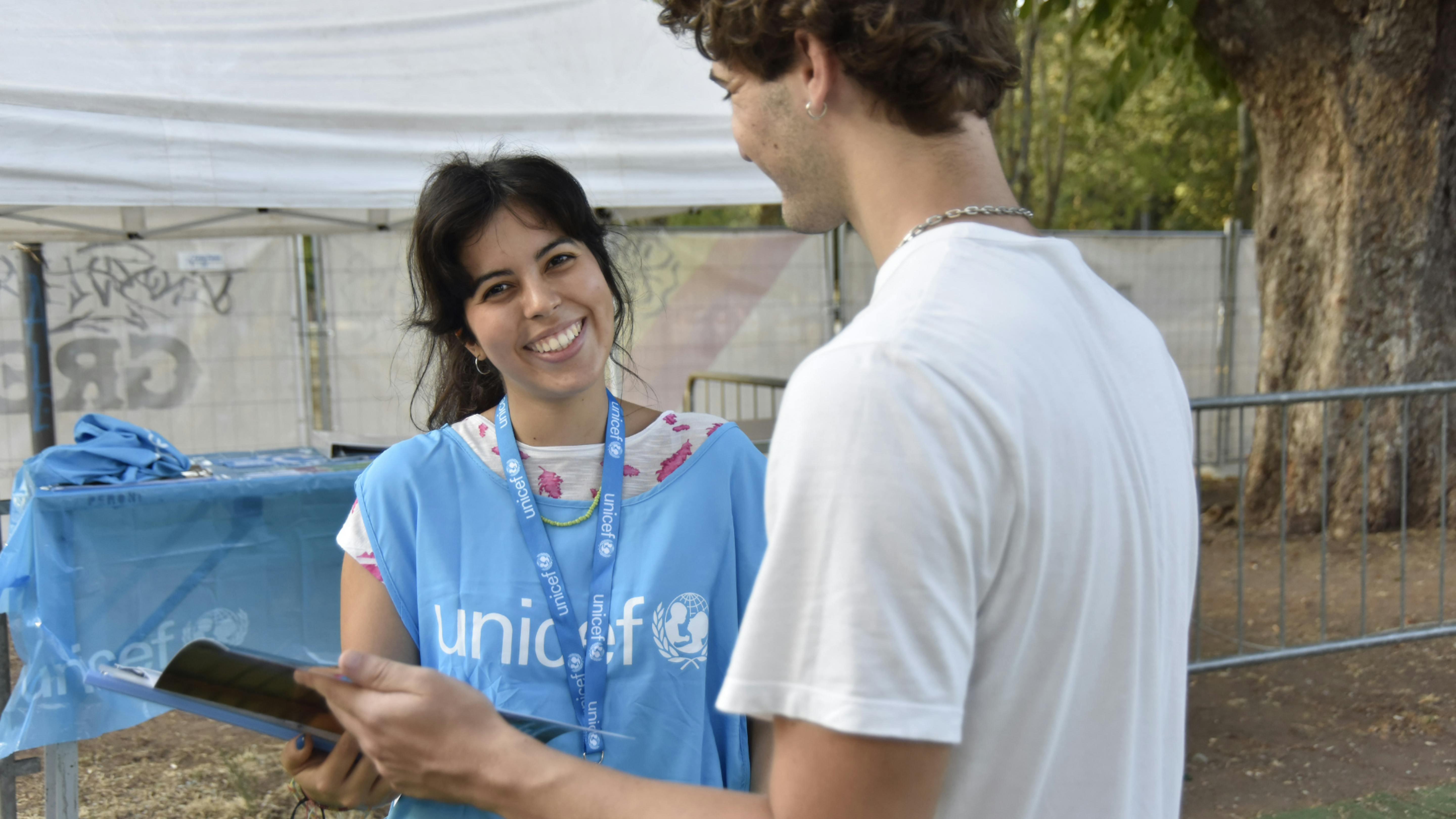 Face to Face - ragazza espone i programmi di UNICEF ad un passante. Credit: Mirko Radi