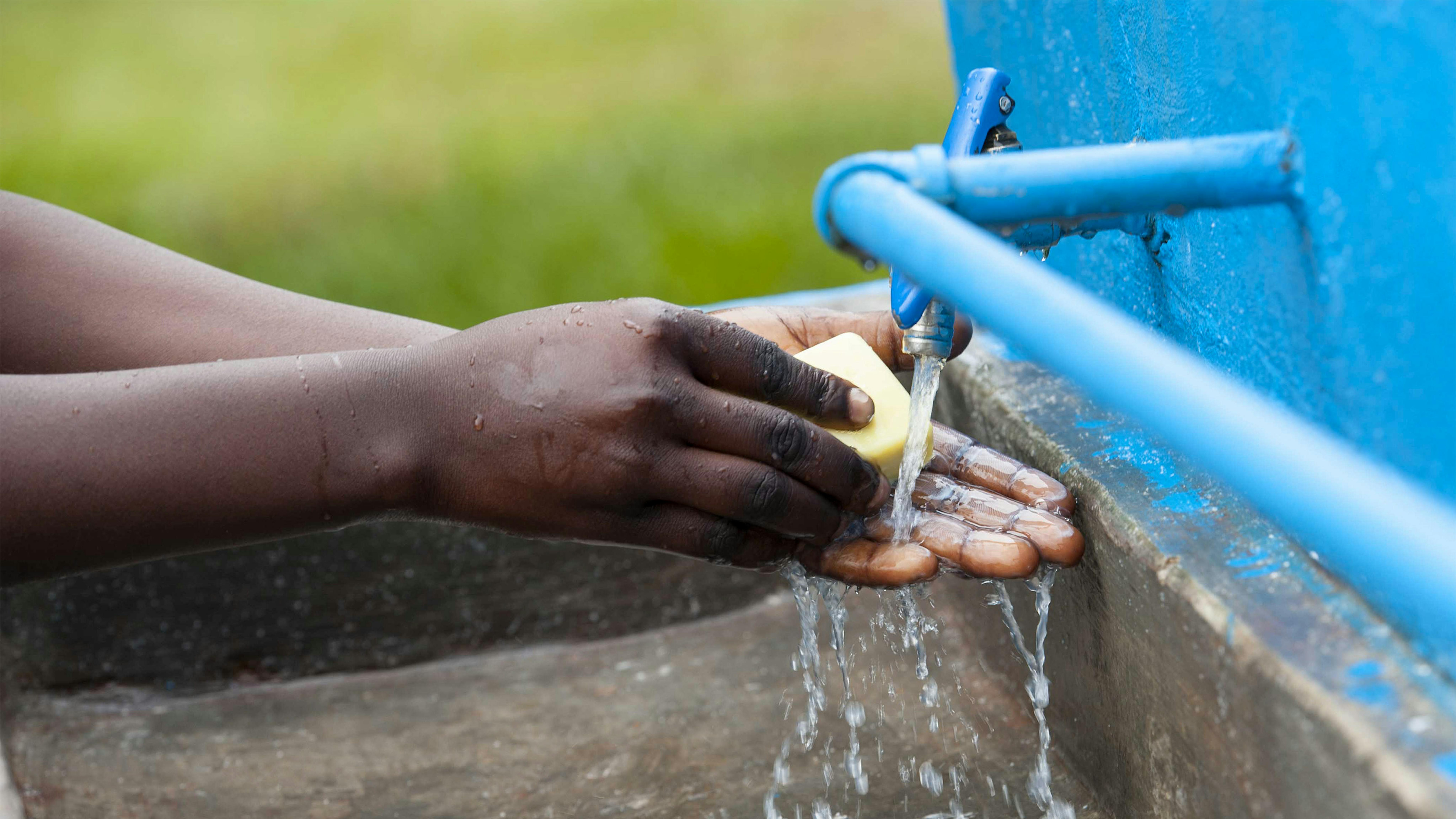 Uganda, un alunno della St. Peteros Kyoga Primary School si lava le mani con il sapone  in una struttura per il lavaggio delle mani.