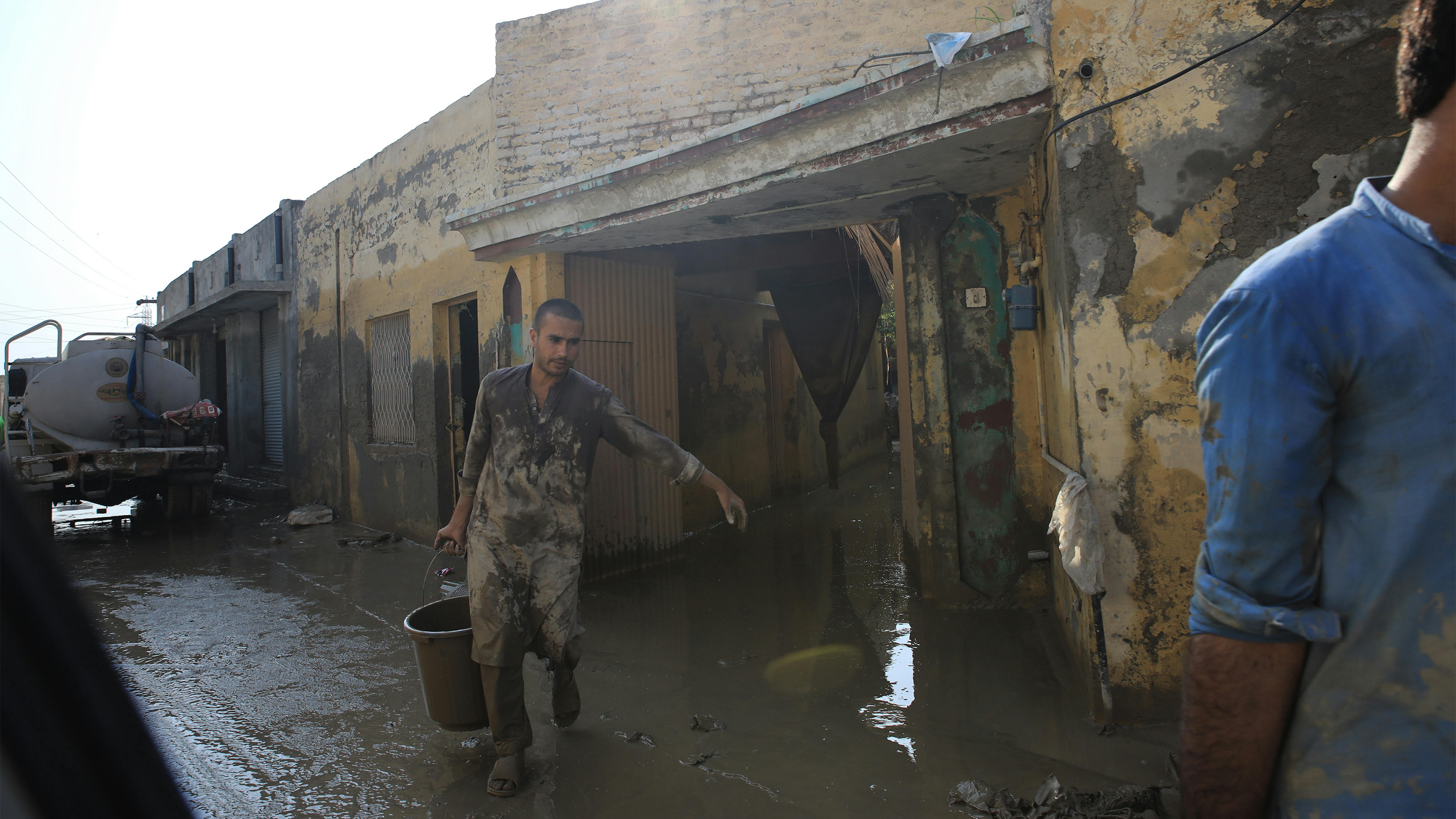 Pakistan, un uomo toglie l'acqua che ha invaso la sua abitazione