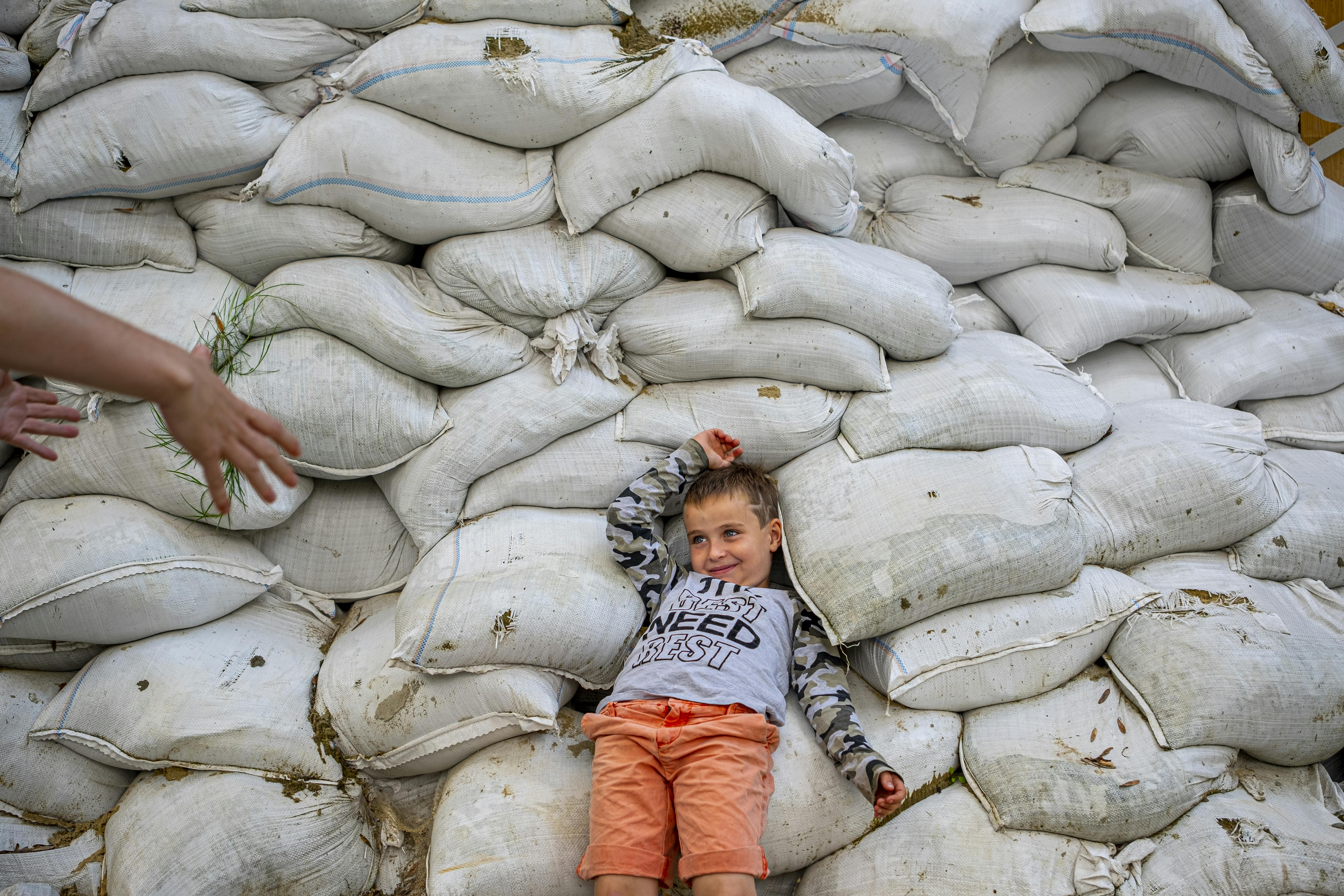 Davyd, 7 anni, è sdraiato su sacchi di sabbia accatastati per proteggere le persone dai proiettilinei pressi del campo per sfollati interni di Lviv, in Ucraina.