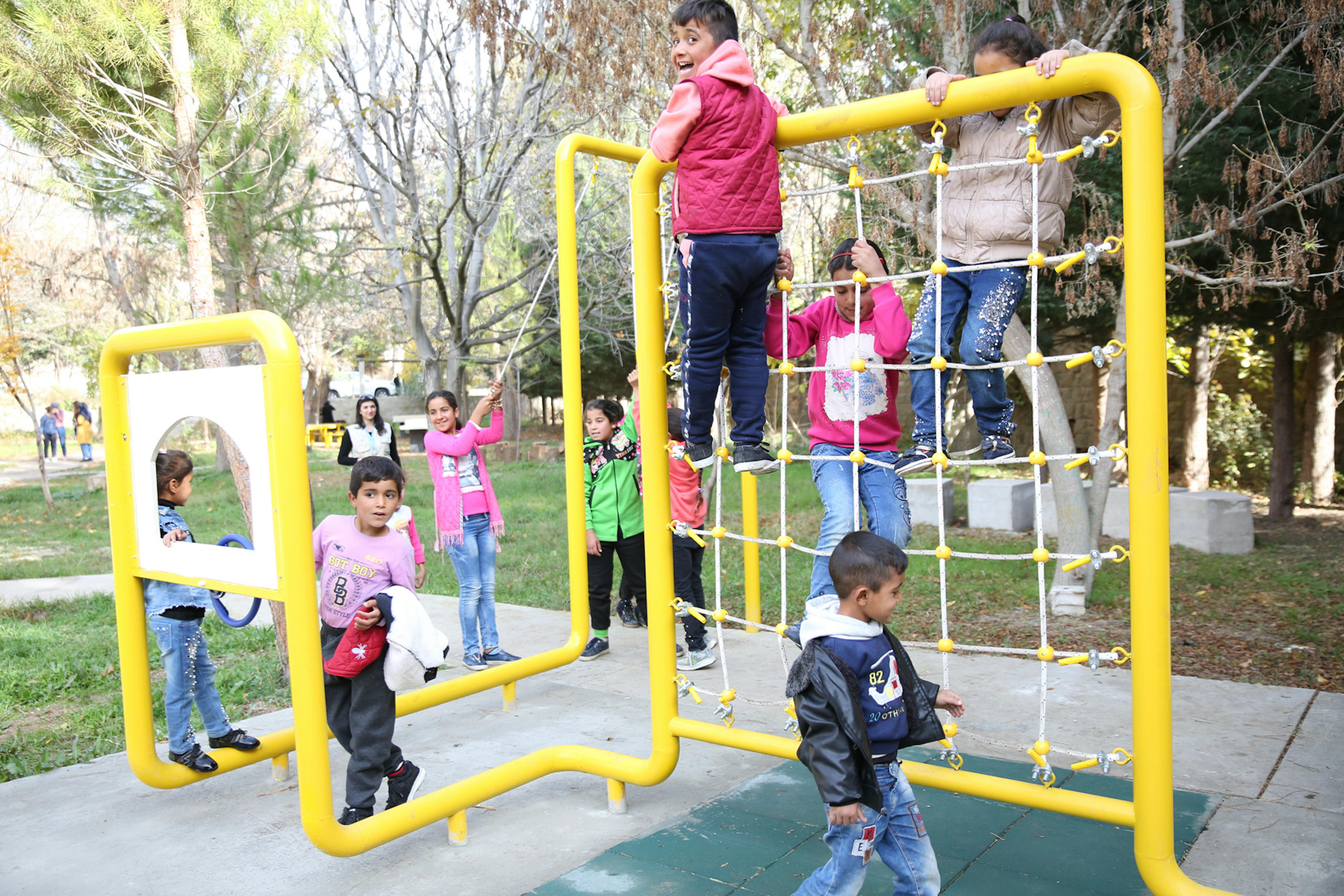 Bambini giocano in un parco pubblico, locandina evento città amiche