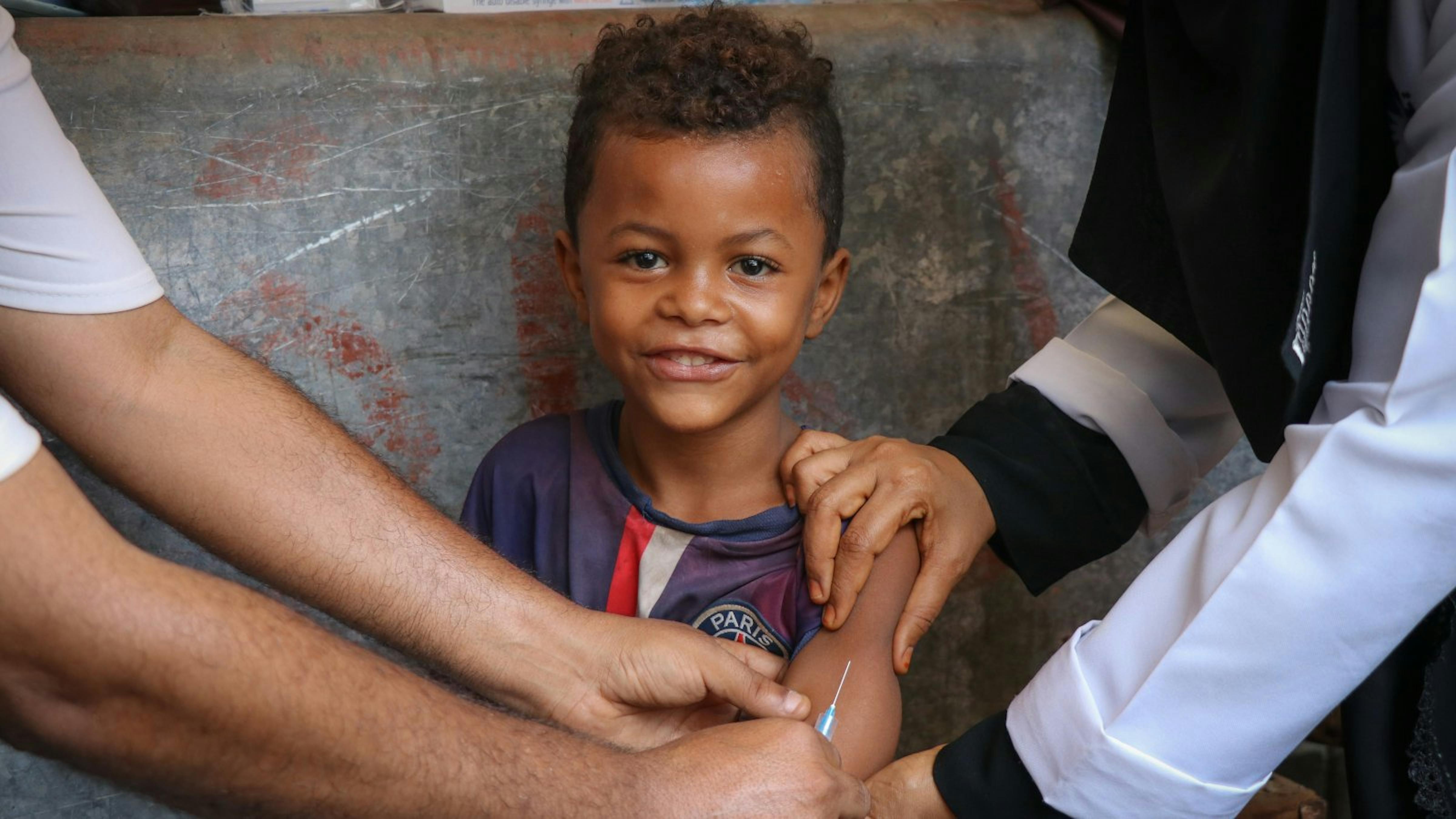 Un bambino sorride mentre riceve il vaccino contro il morbillo e la rosolia durante una campagna di vaccinazione mobile sostenuta dall'UNICEF ad Aden, Yemen, il 9 febbraio 2019.