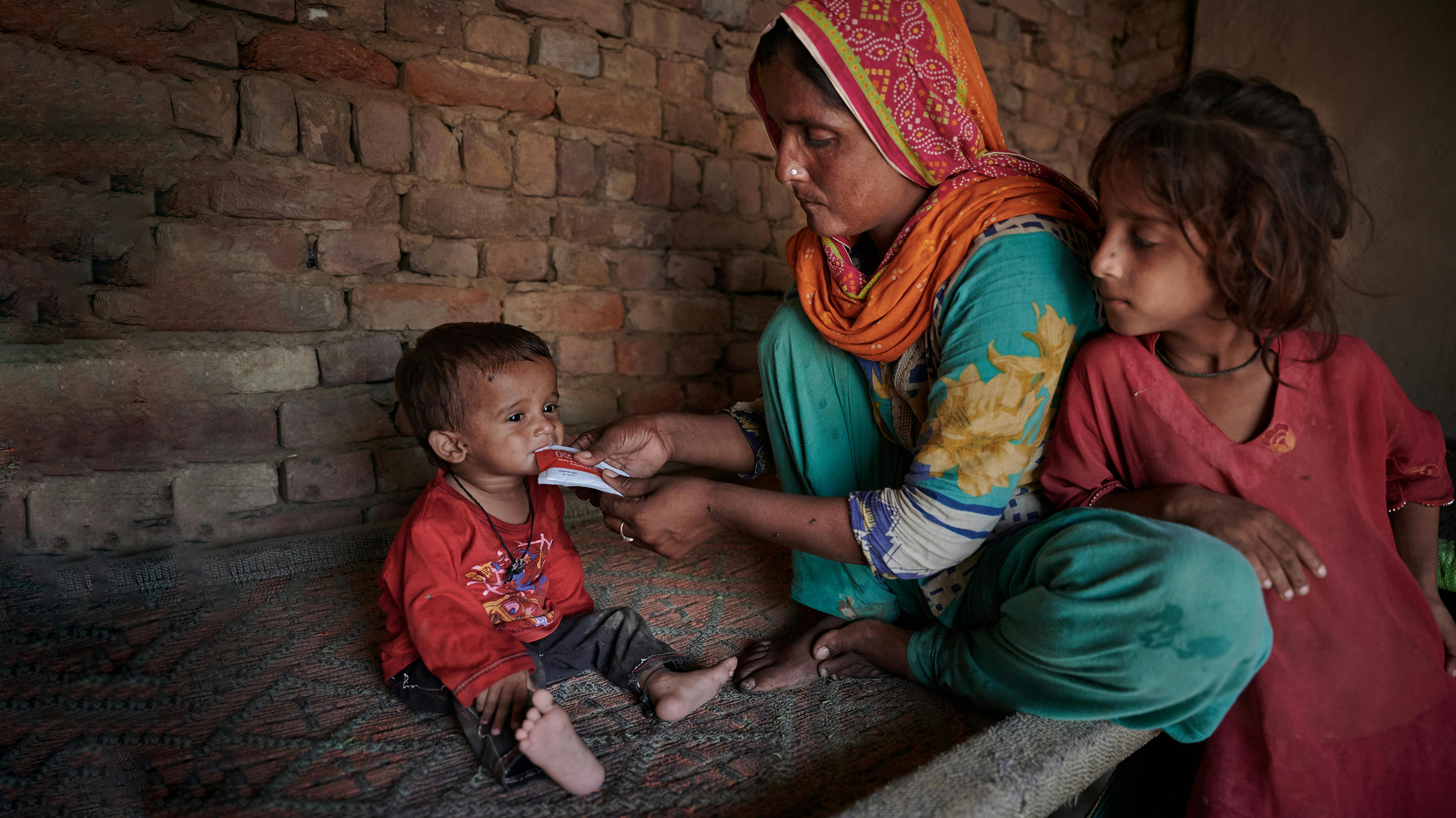 Pakistan - Reshma nutre suo figlio Azaan Ali (16 mesi) con il RUTF che ha ricevuto dalla clinica mobile sostenuta dall'UNICEF al villaggio Ismail Bhand,