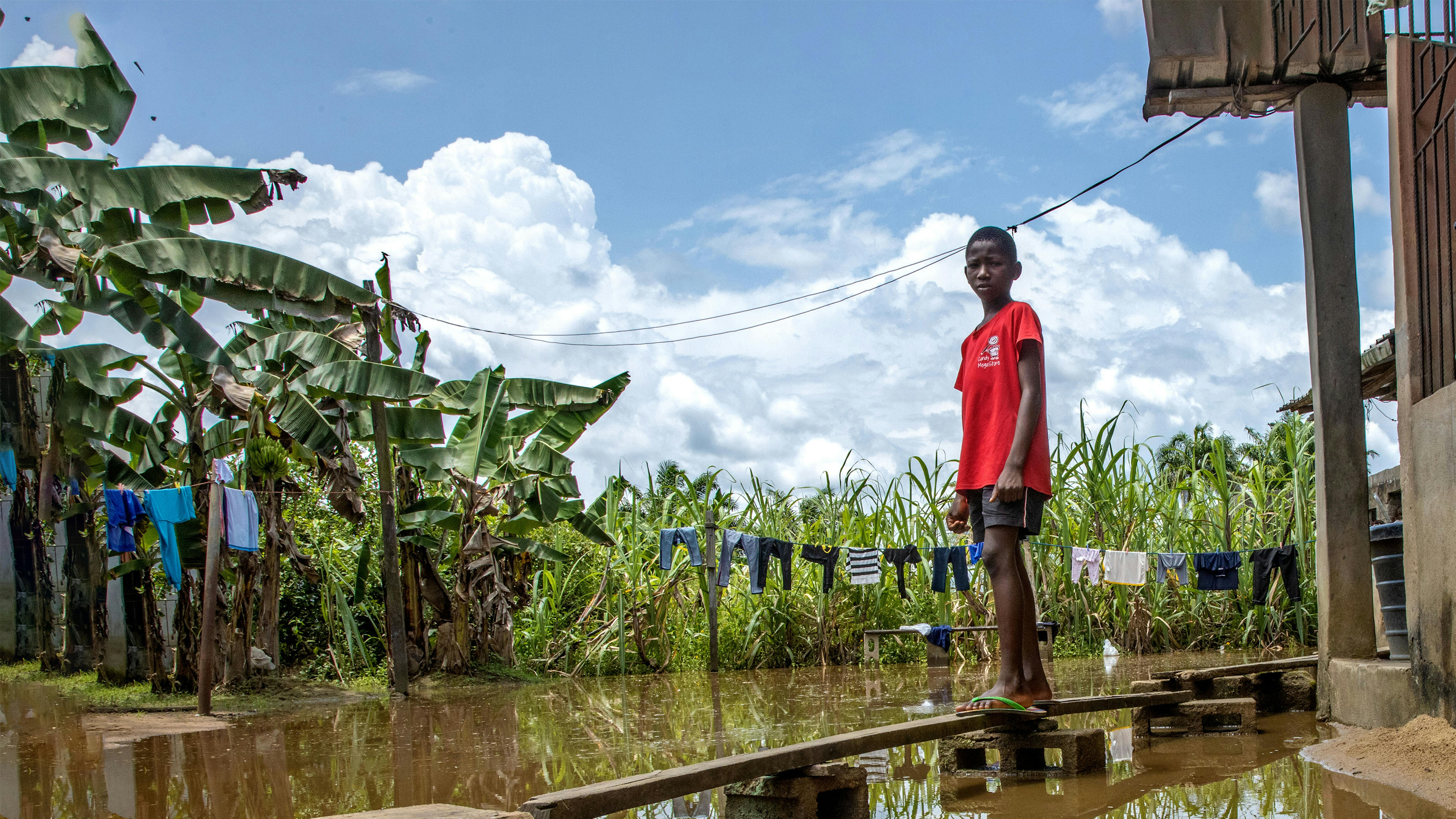 Nigeria - Peretimfa Germania 11 anni, è in piedi sulla passerella improvvisata di legno davanti alla sua casa colpita dall'alluvione a Sagbama, Bayelsa