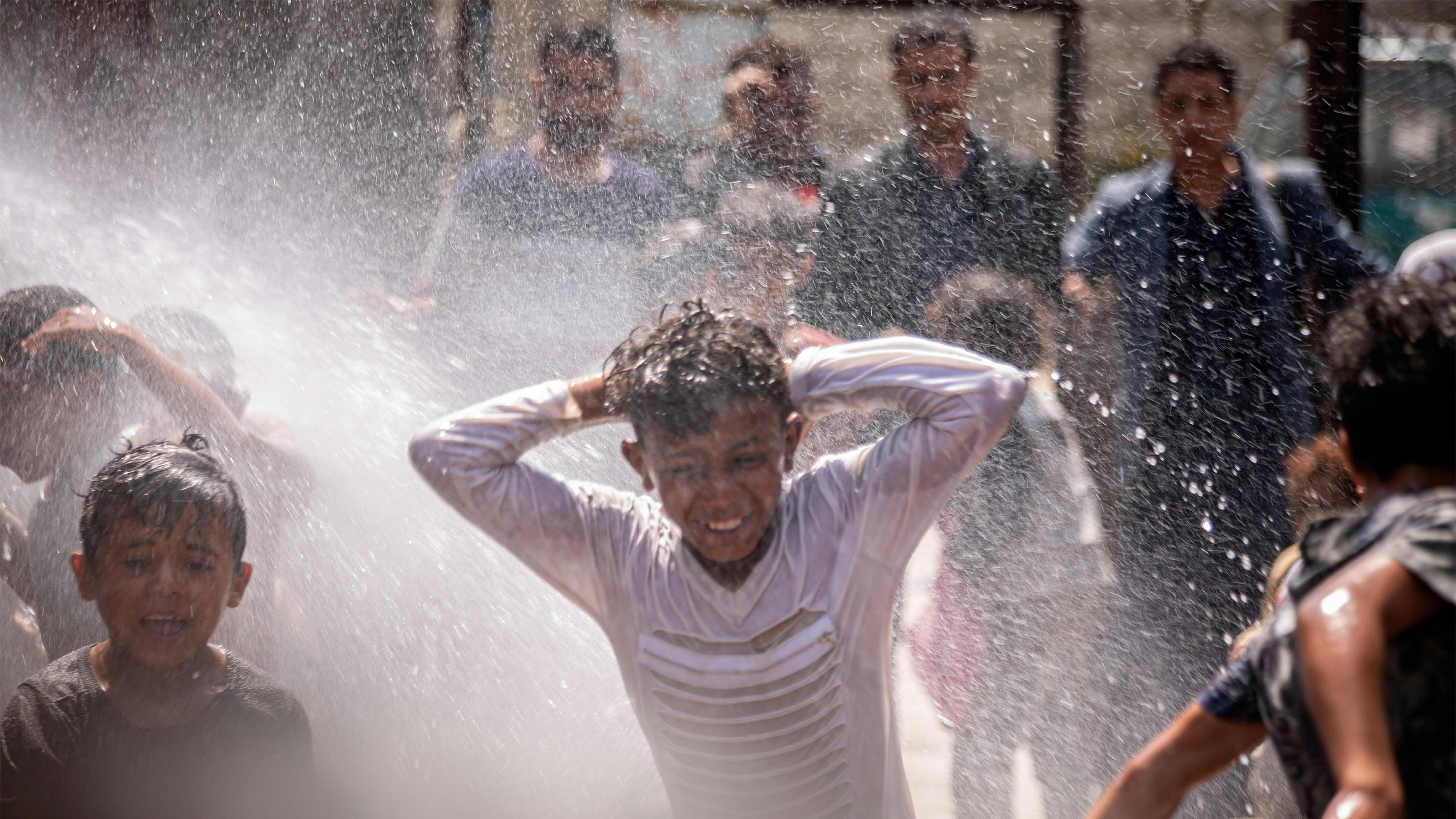 Yemen - I bambini sono felici di giocare con l'acqua dopo aver sofferto per la scarsità d'acqua nel campo per sfollati interni di Ibb