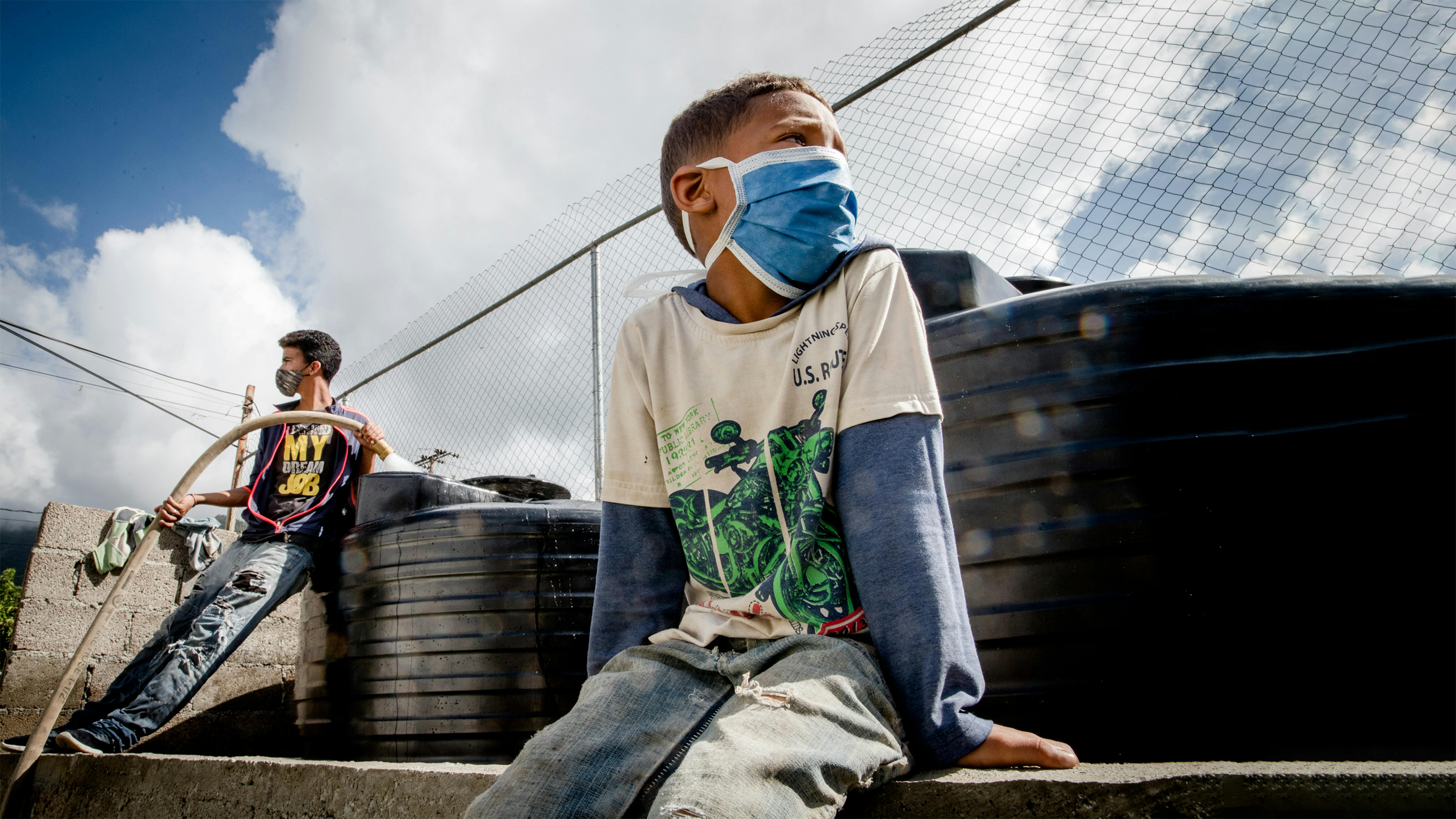 Venezuela - Eduardo Escalona (sullo sfondo) e Samuel Cardona riempiono i serbatoi d'acqua installati con il supporto dell'UNICEF