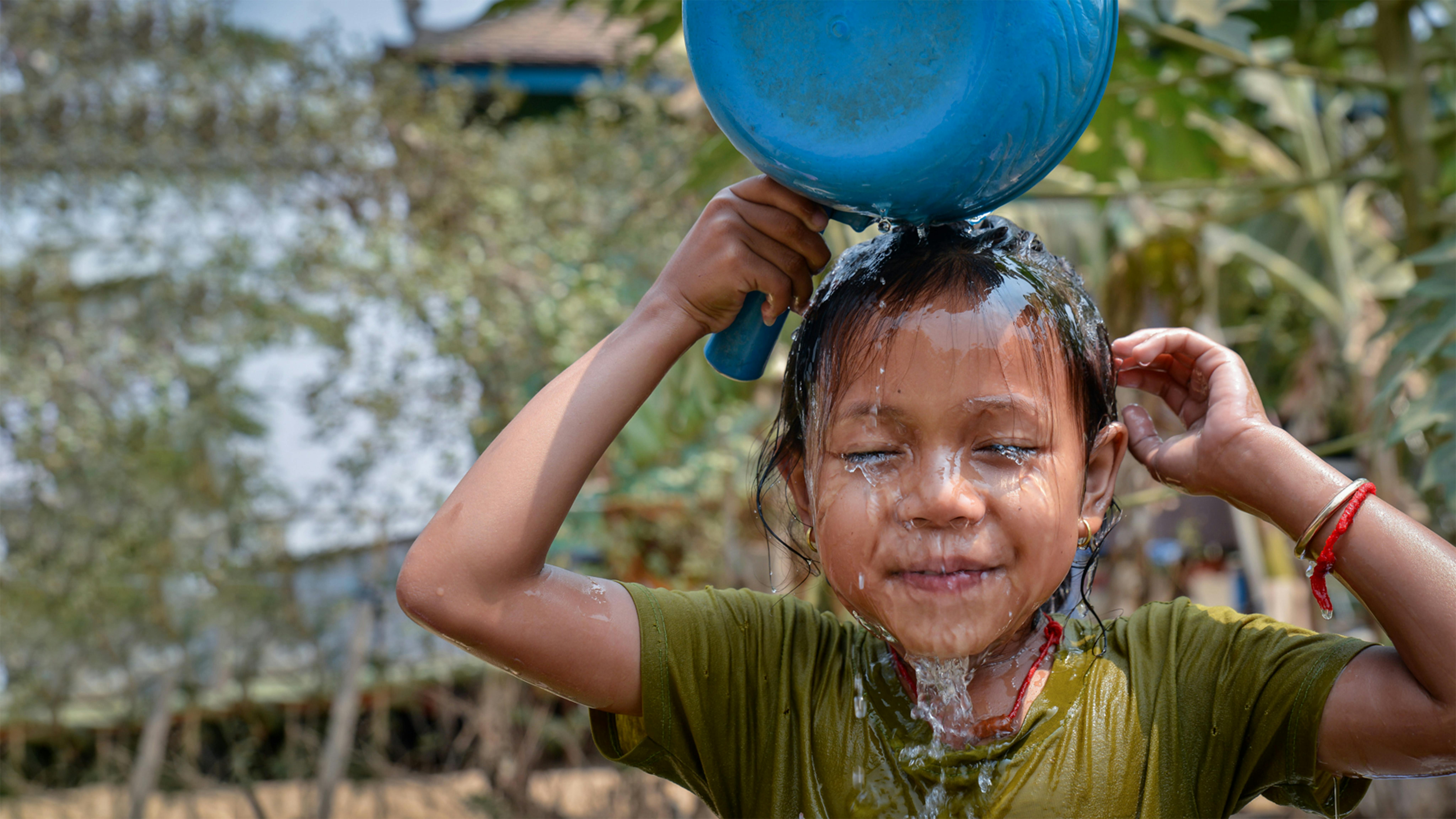 Cambogia - Mara, 5 anni, si fa la doccia quotidiana dopo la scuola.