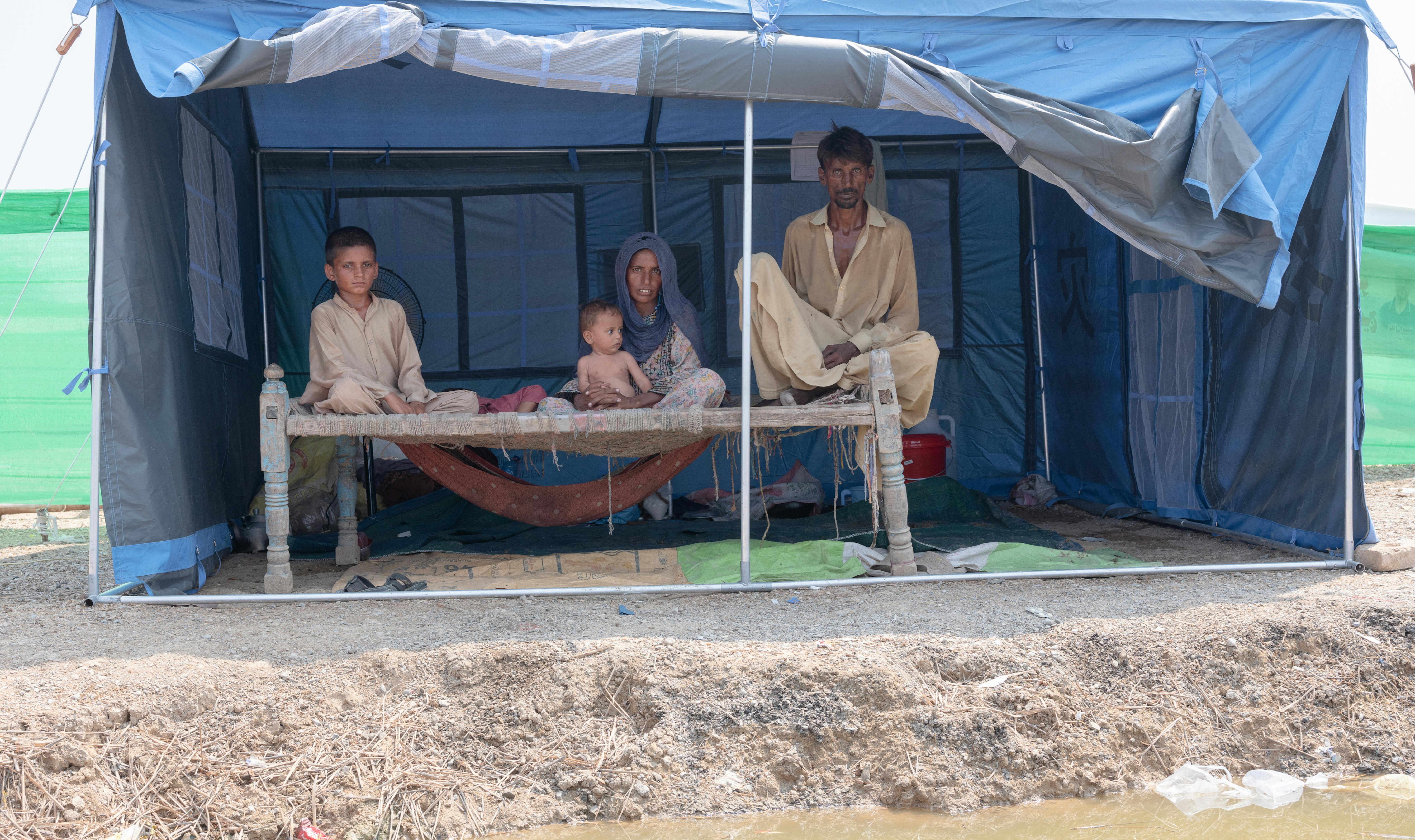 Pakistan - una famiglia in una piccola tenda  in un campo per persone colpite dall'alluvione