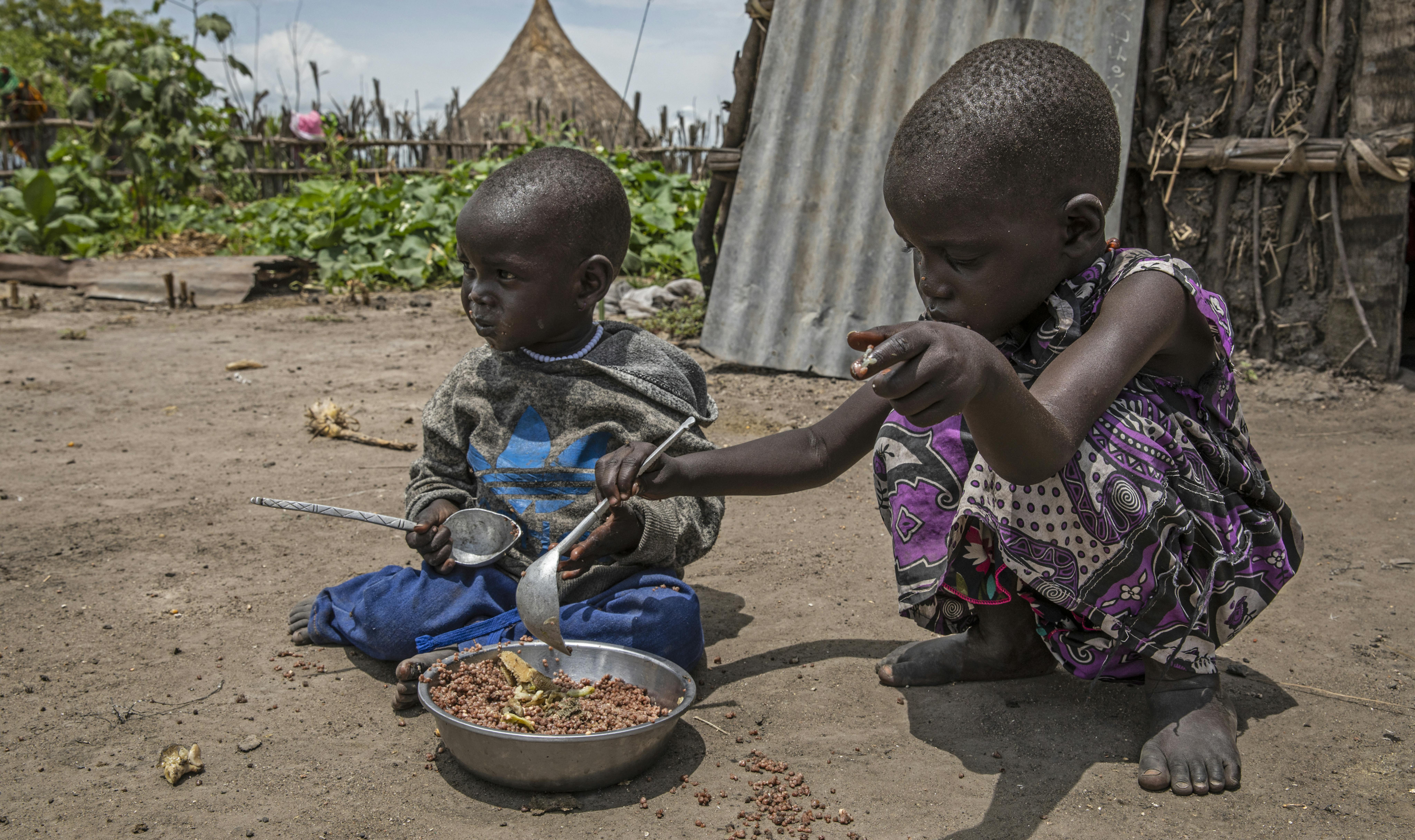 Nyaran e Nyagori  condividono un pasto fuori dalla loro capanna di famiglia a Thonyor, nella contea di Leer - © WFP/1682654