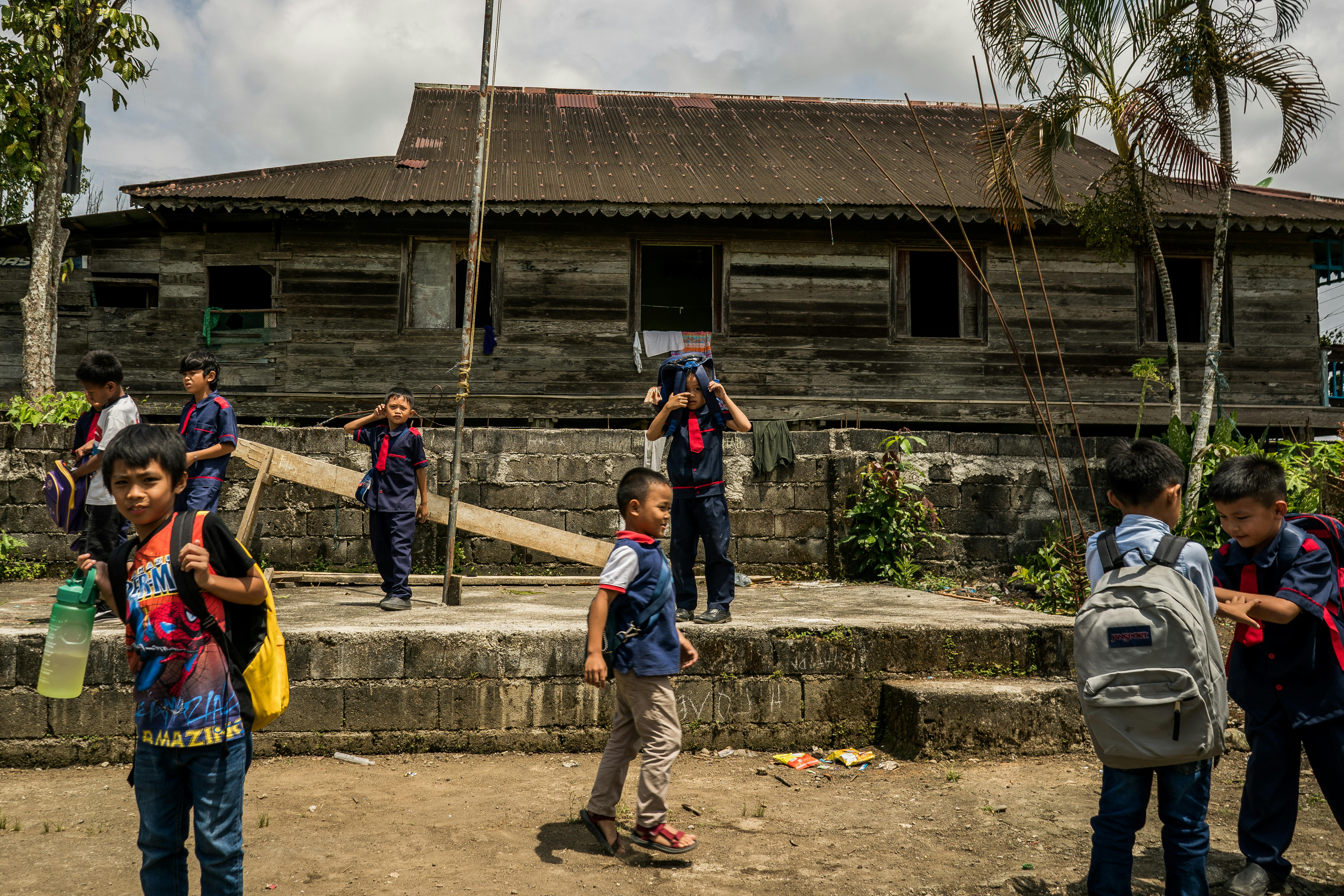 Filippine, Baniamen va a prendere tre dei suoi figli a scuola usando il suo triciclo, che usa anche per lavoro.