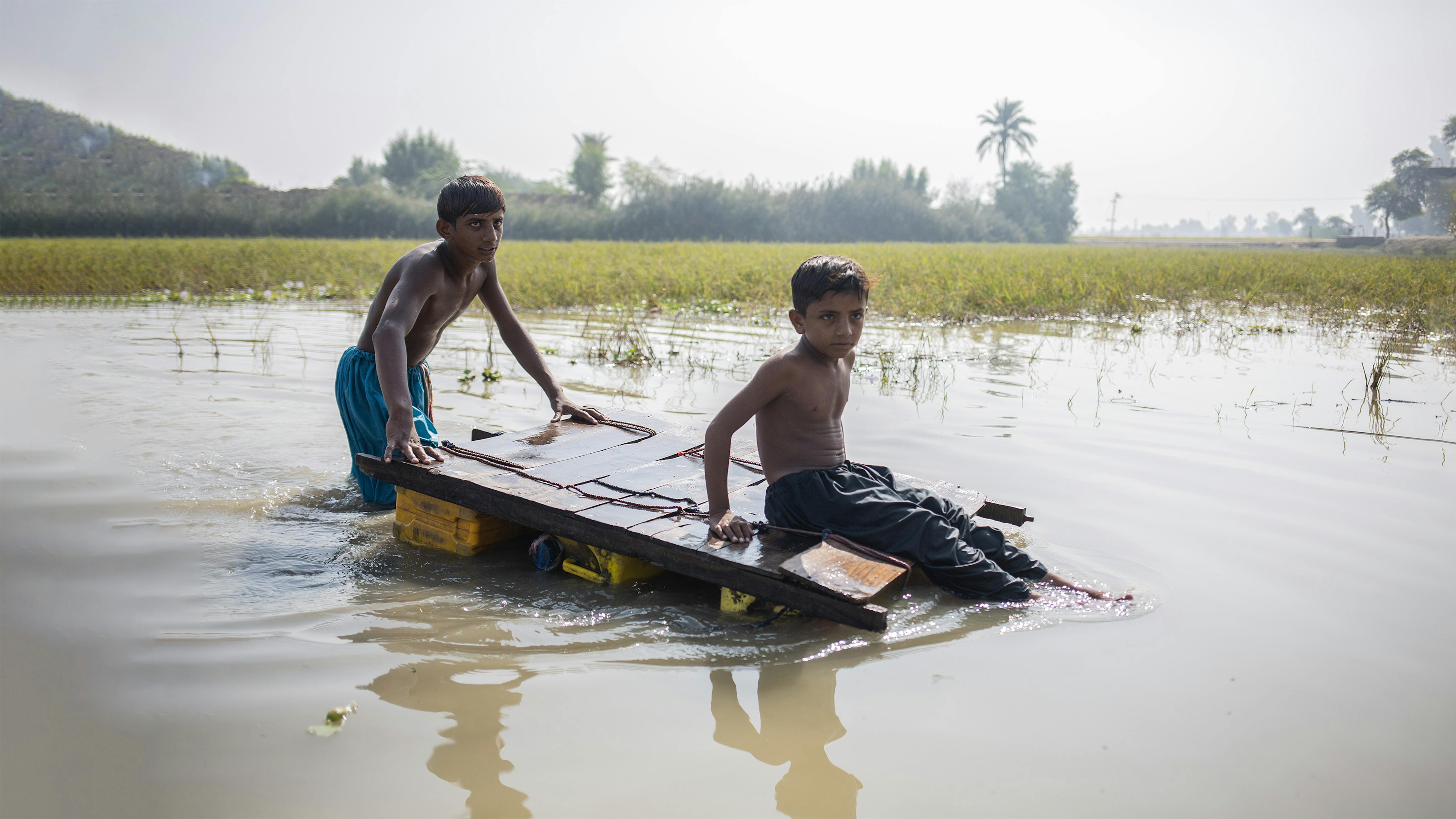 Pakistan, due bambini tornano a casa attraverso l'acqua contaminata causata dalle inondazioni