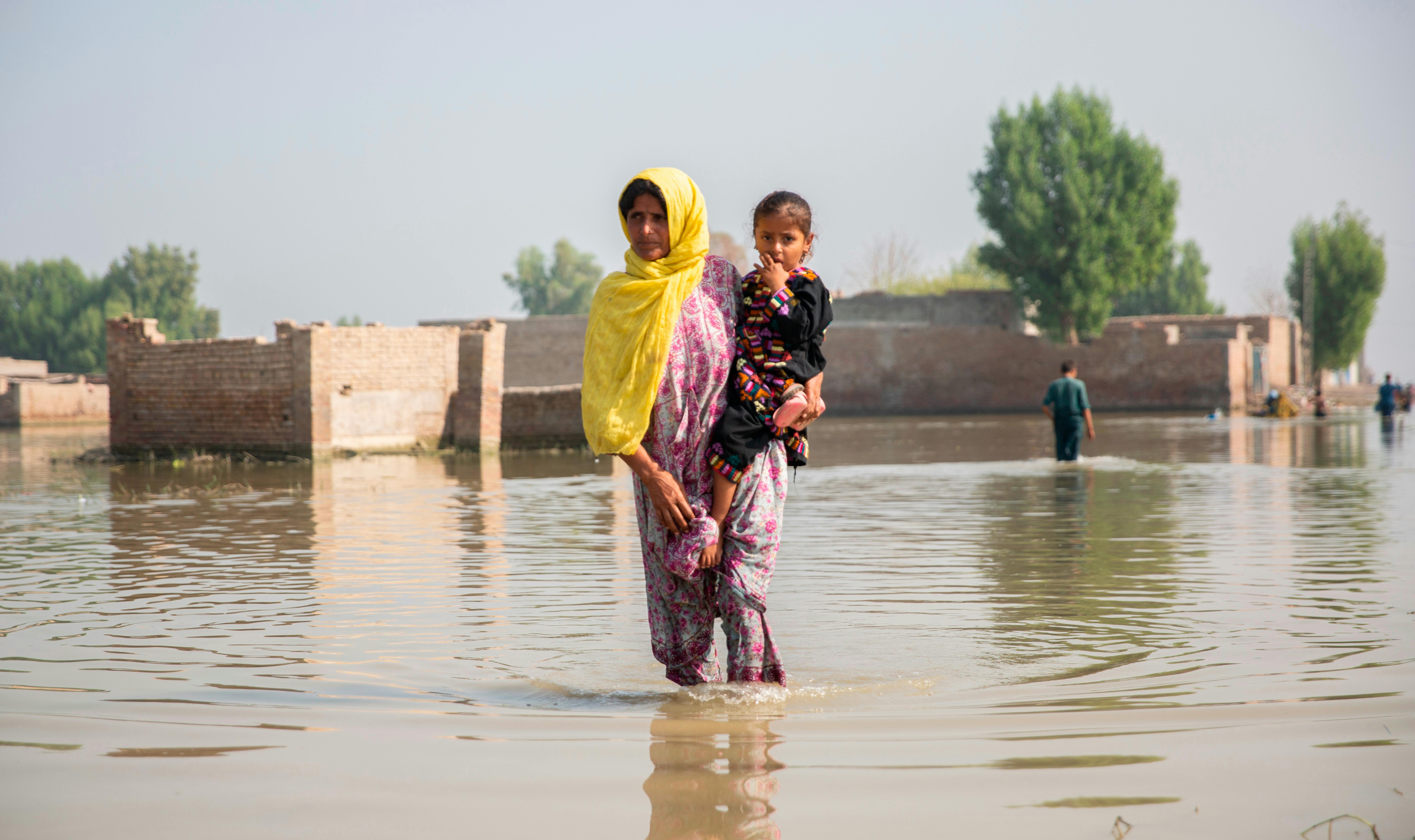 Pakistan, Aneefa Bibi tiene in braccio la figlia di 5 anni, Hood, che soffre di febbre e dolori al petto.