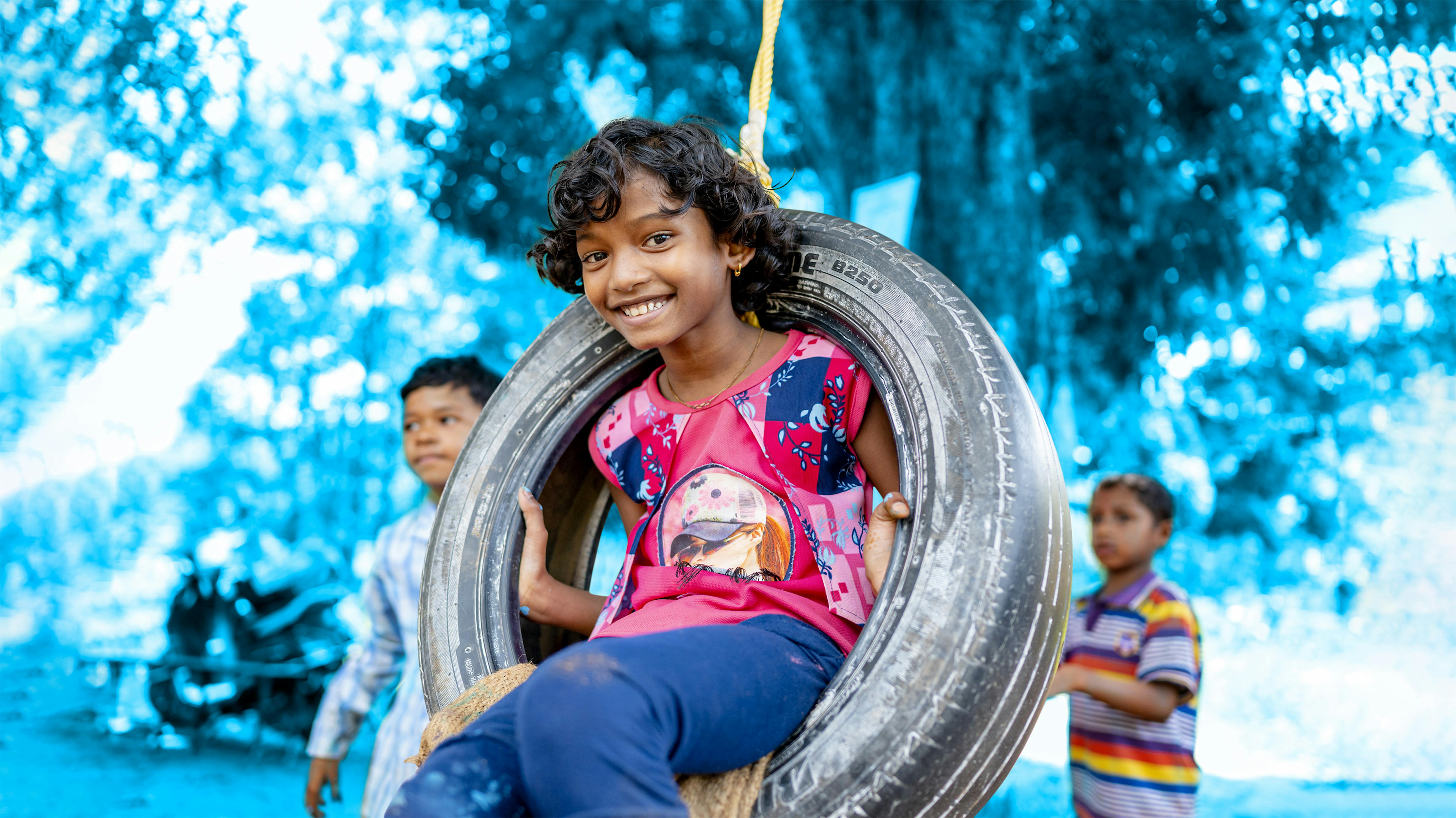 World's Children Day 2022: bambina gioca con un vecchio pneumatico