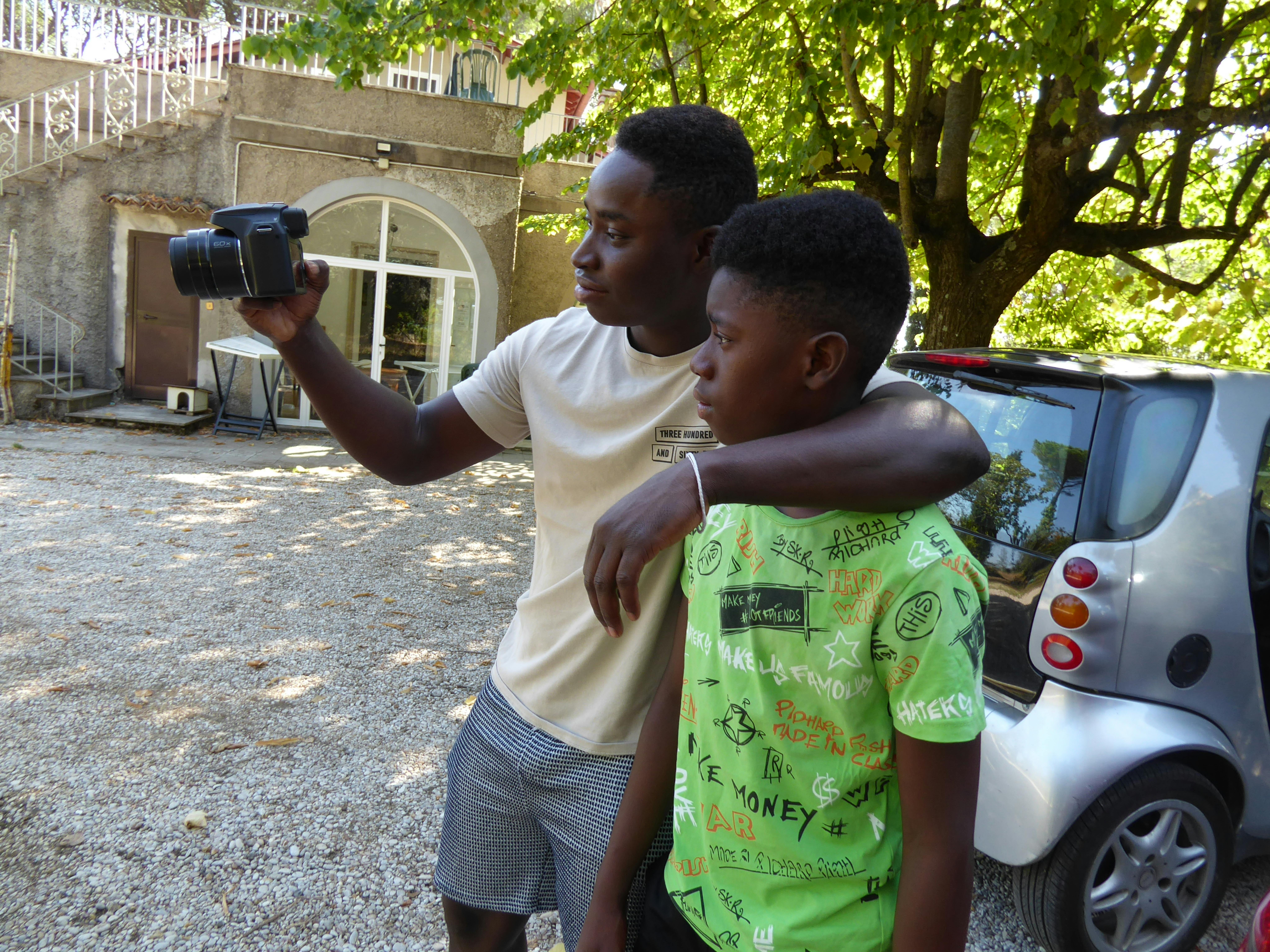 Mamoudou insieme al fratello guardano l'inquadratura della fotocamera