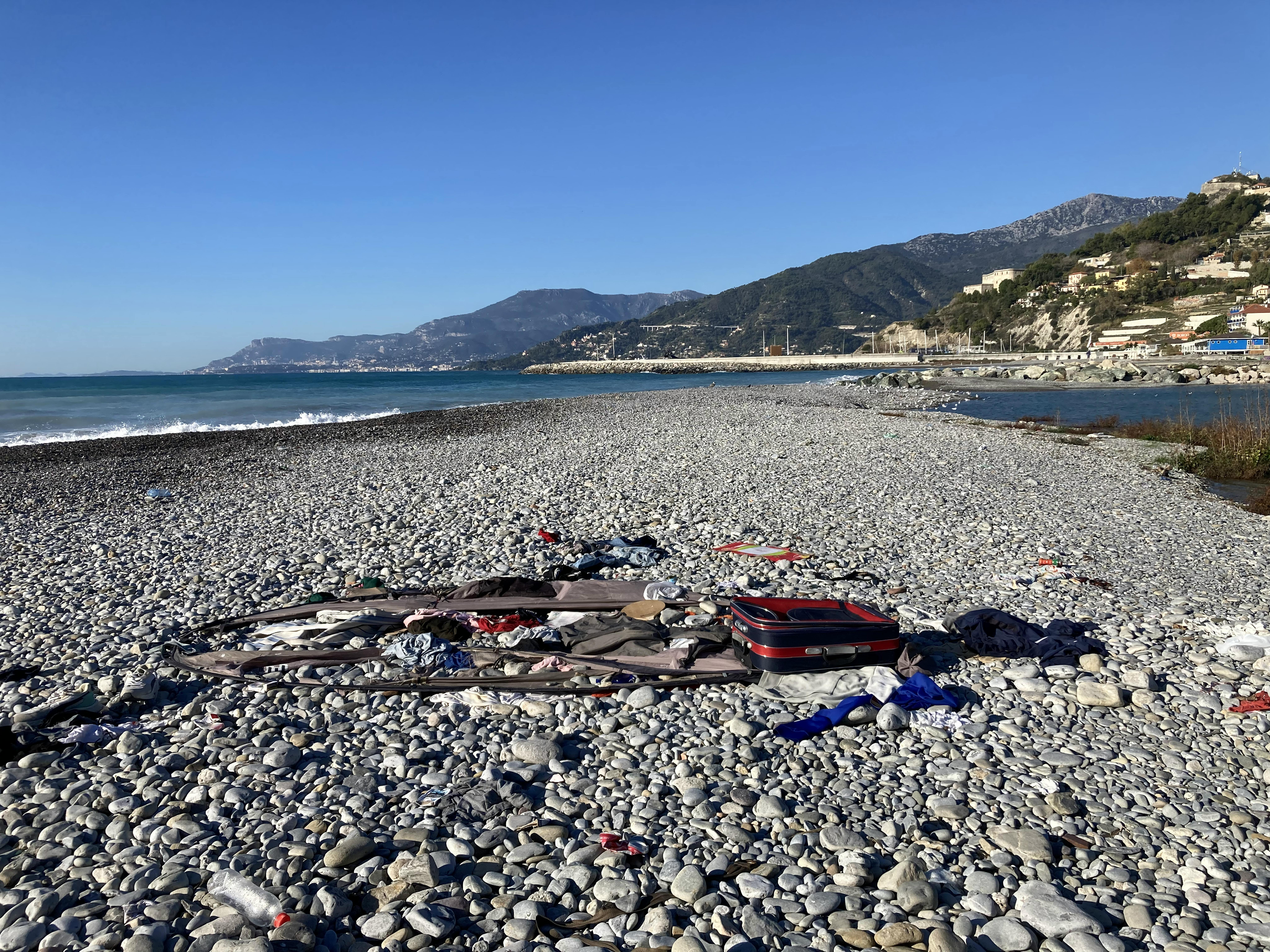 I resti di una tenda, valigia e abiti lasciati in spiaggia