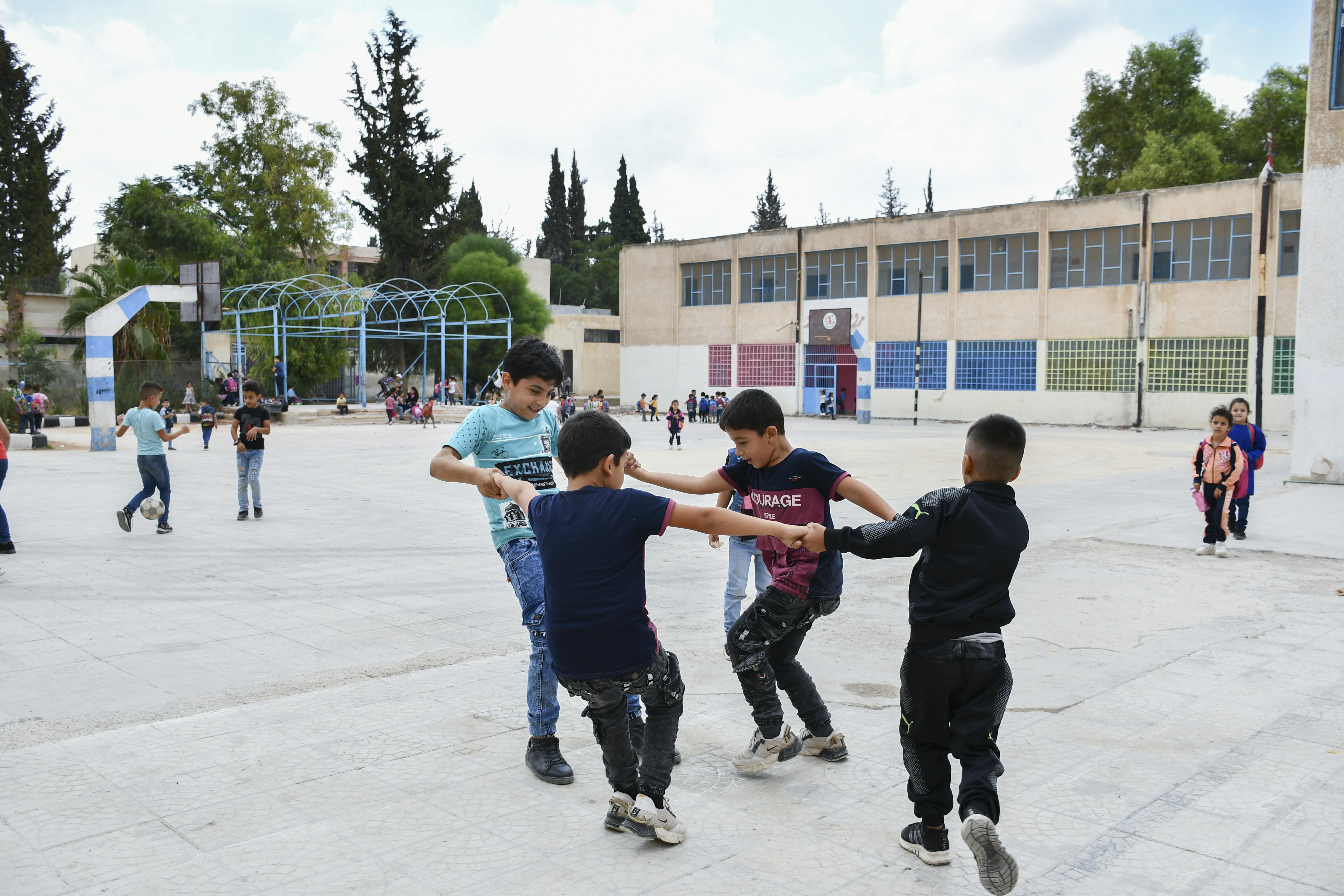 Ahmad, 11 anni, gioca con i suoi nuovi amici nel cortile della sua scuola nella città di Dar'a, nel sud della Siria, il 19 settembre 2022.