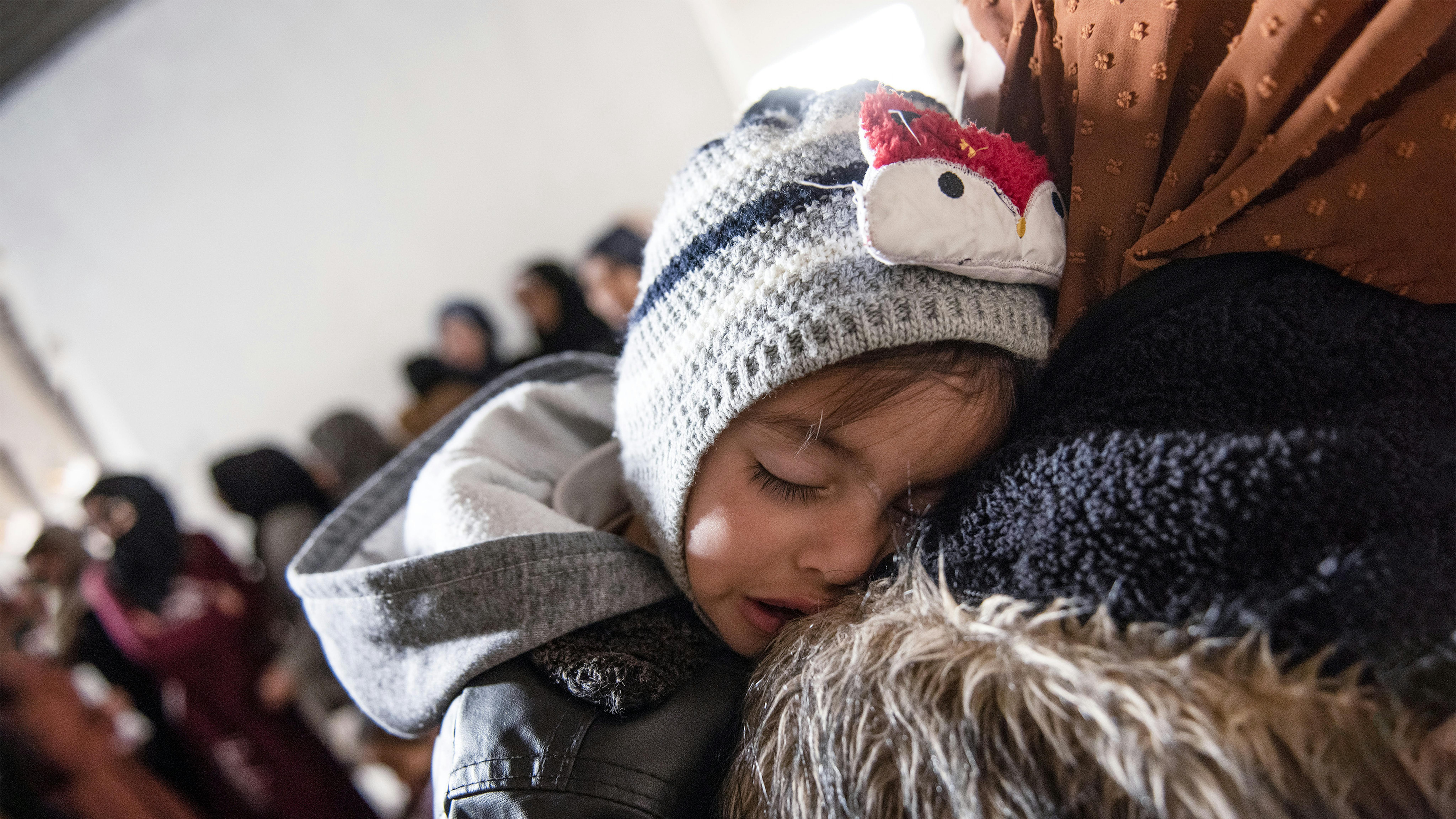 Siria - Ishak, 1 anno e mezzo, dorme sulla spalla di sua madre Abir mentre è in attesa di effettuare un controllo sanitario e uno screening per la malnutrizione  nel villaggio di Jarba nella Ghouta orientale