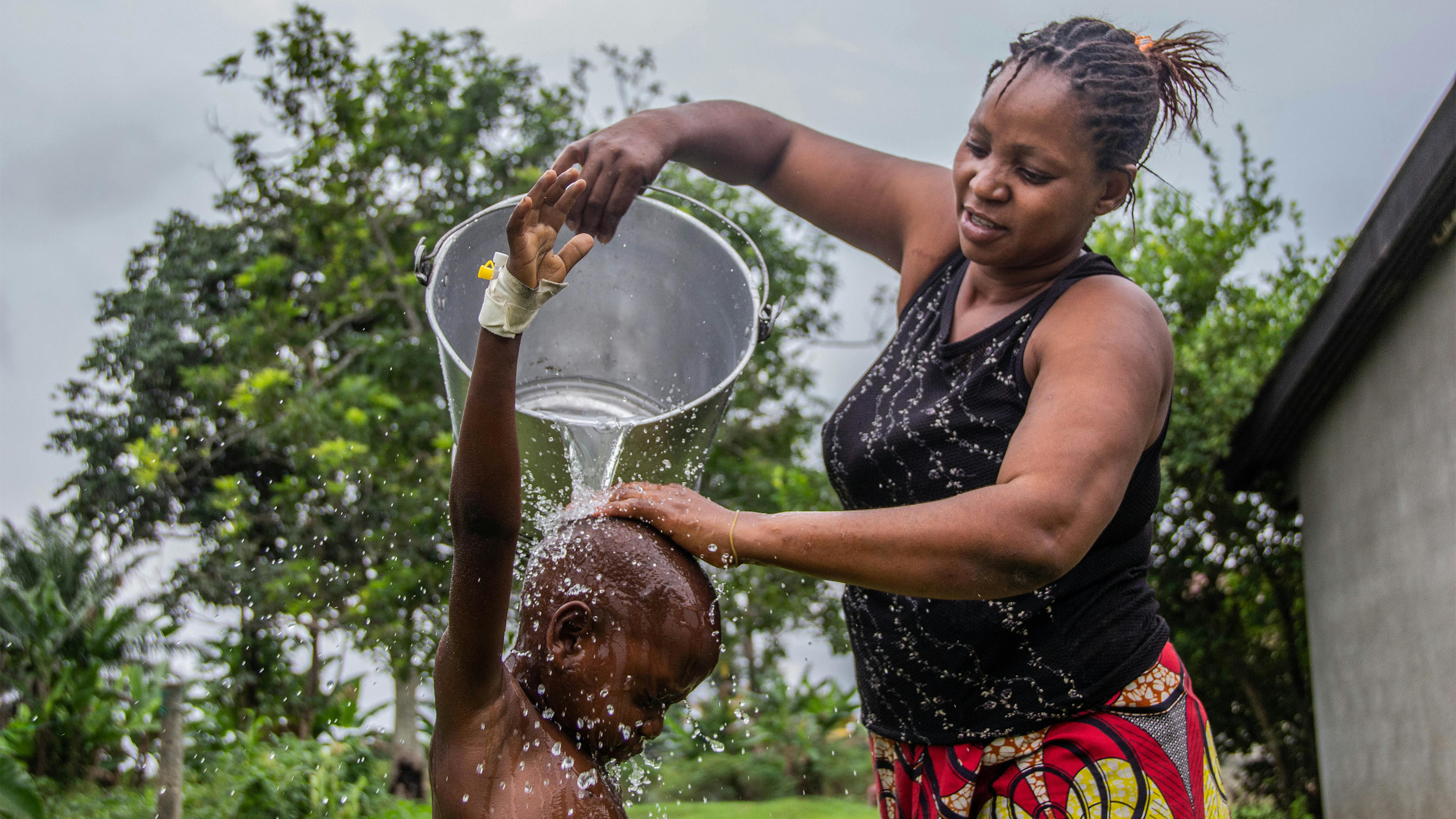 Congo, una mamma lava suo figlio da una grondaia al General Hospital di Kabondo a Kisangani nella provincia di Tshopo