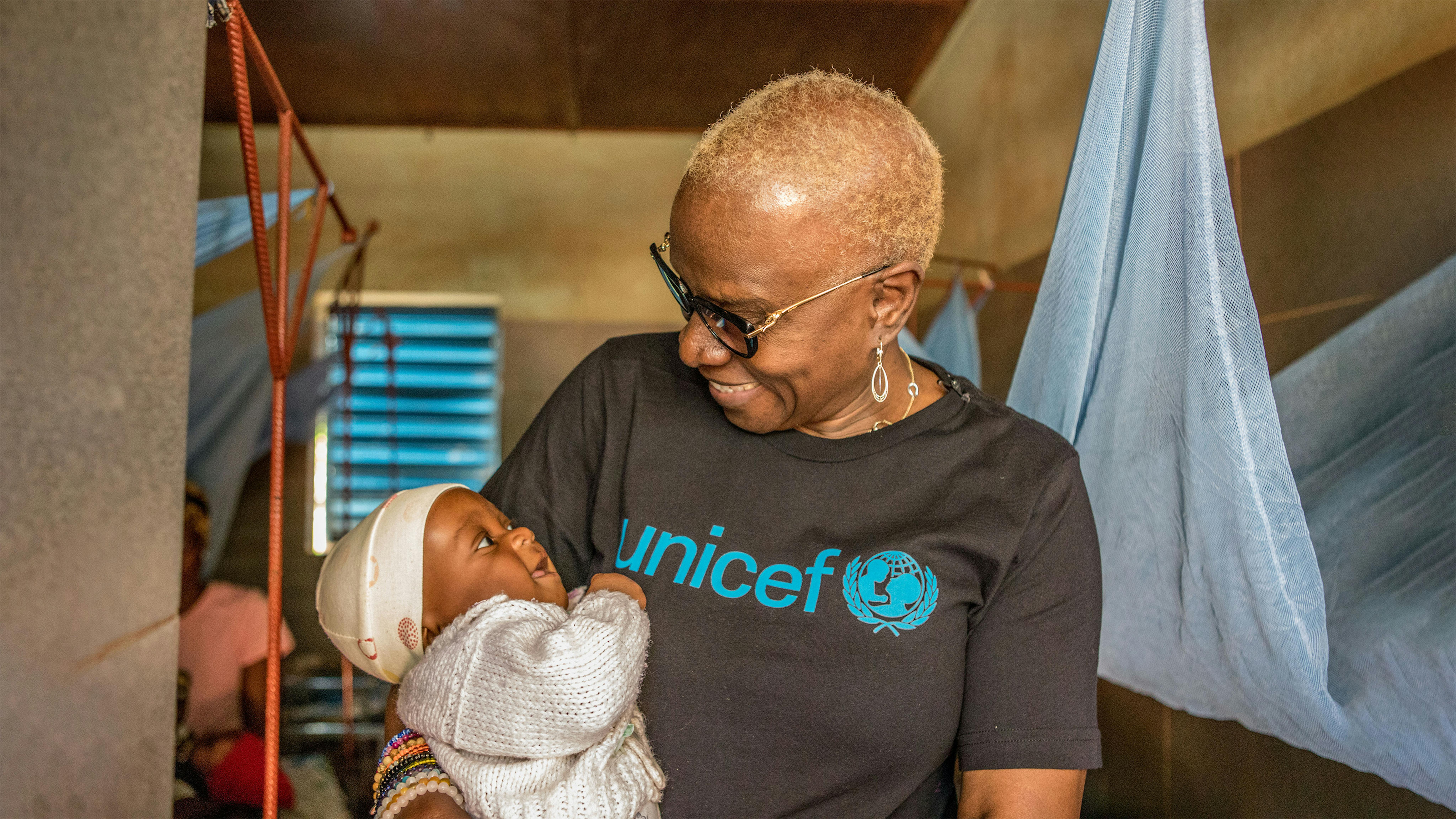 Benin, L'ambasciatrice dell'UNICEF Angélique Kidjo tiene in braccio un bambino  nel centro nutrizionale al Saint Jean de Dieu Hospital di Tanguiéta.