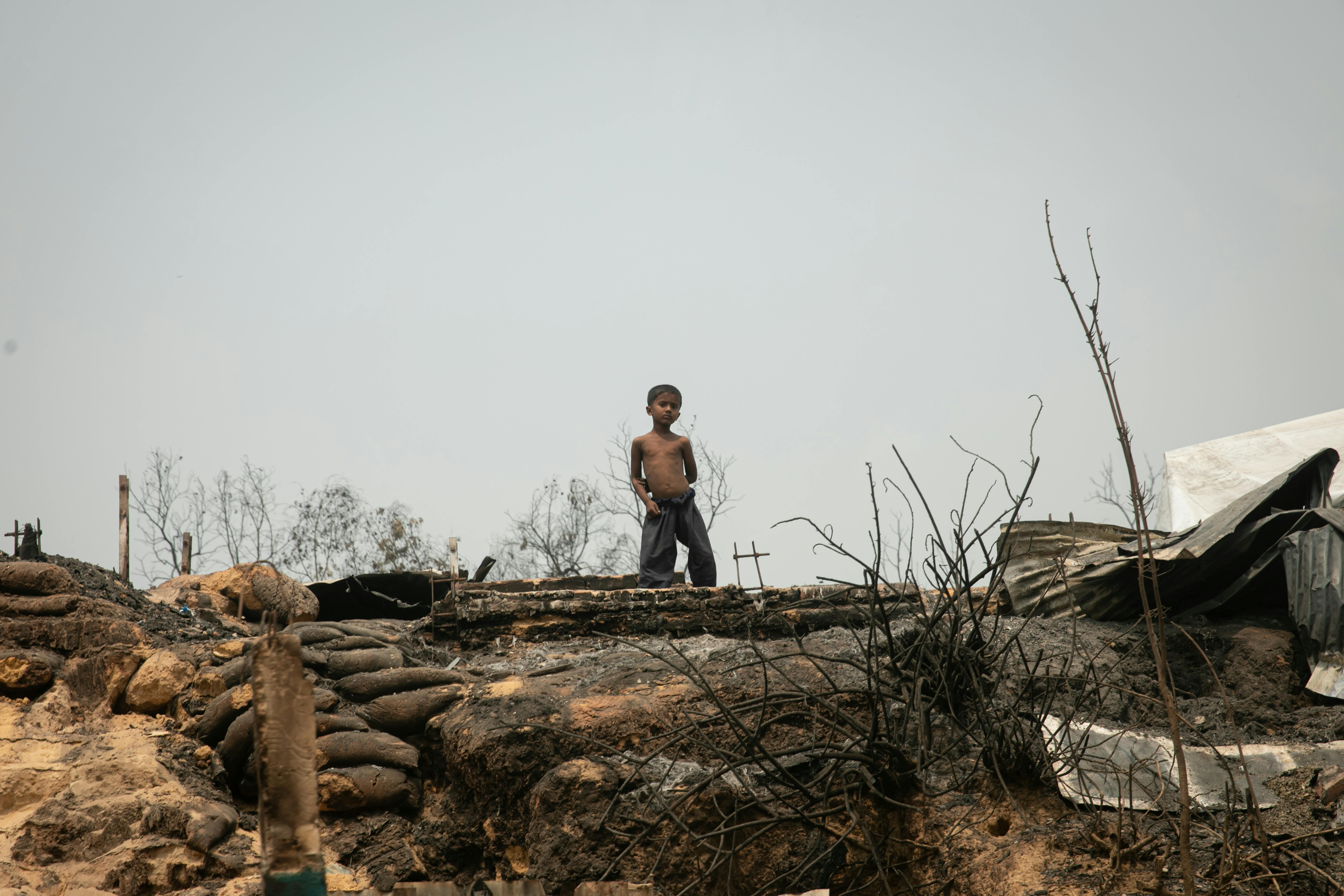Un bambino si trova tra le rovine dell'incendio che ha devastato l'area Balukhali nel campo profughi Rohingya a Cox's Bazar. Migliaia di case sono state distrutte sconvolgendo la vita delle famiglie Rohingya e dei bambini che vivono nei campi profughi.