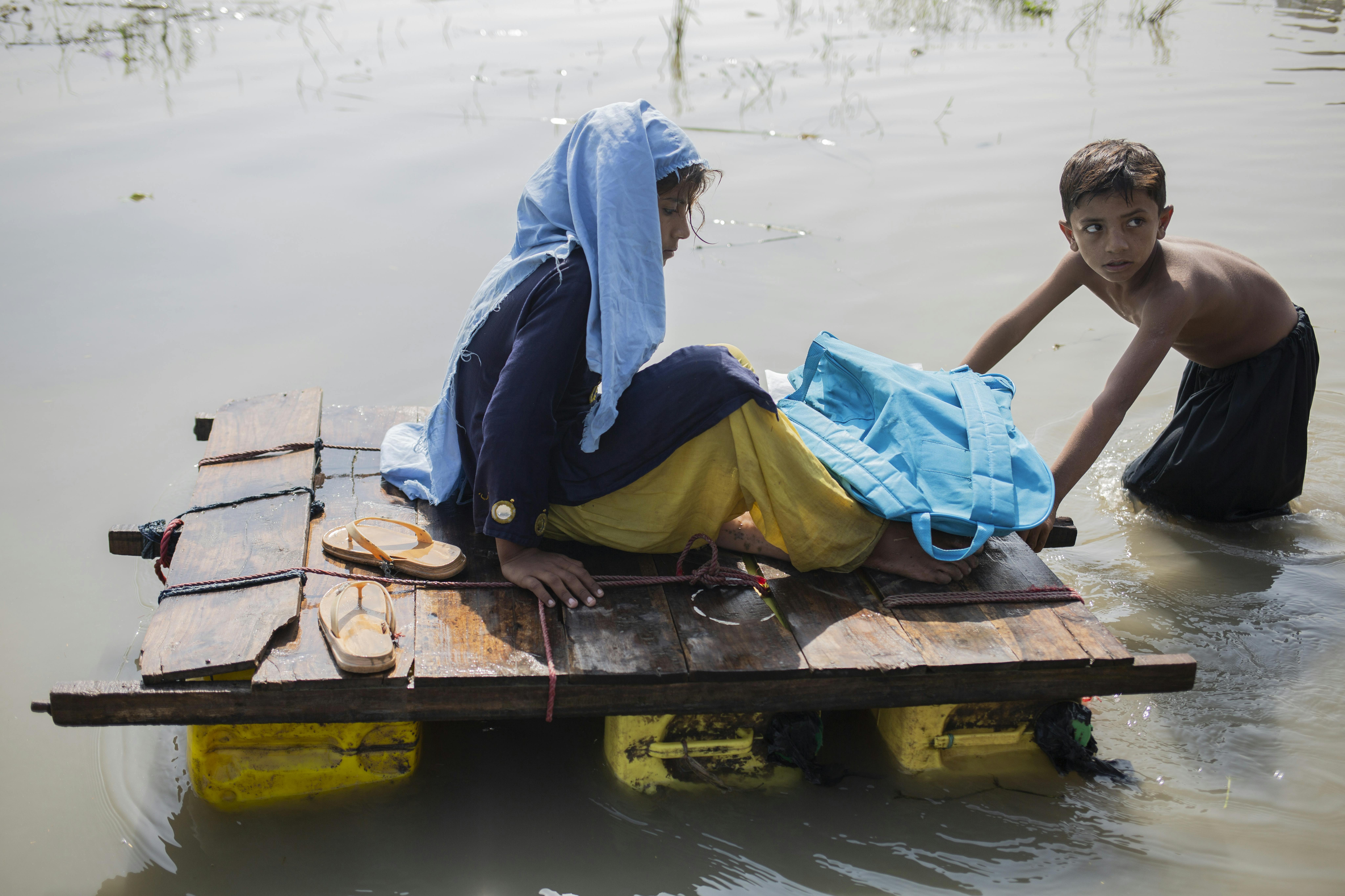 Il 3 novembre 2022 a Jacobabad, nella provincia del Sindh, in Pakistan, questi bambini provano a tornare a casa con una zattera improvvisata dopo l'alluvione. Quest'area richiede la massima attenzione poiché la malaria, la pelle e altre malattie sono in aumento tra la gente del posto, soprattutto tra i bambini.