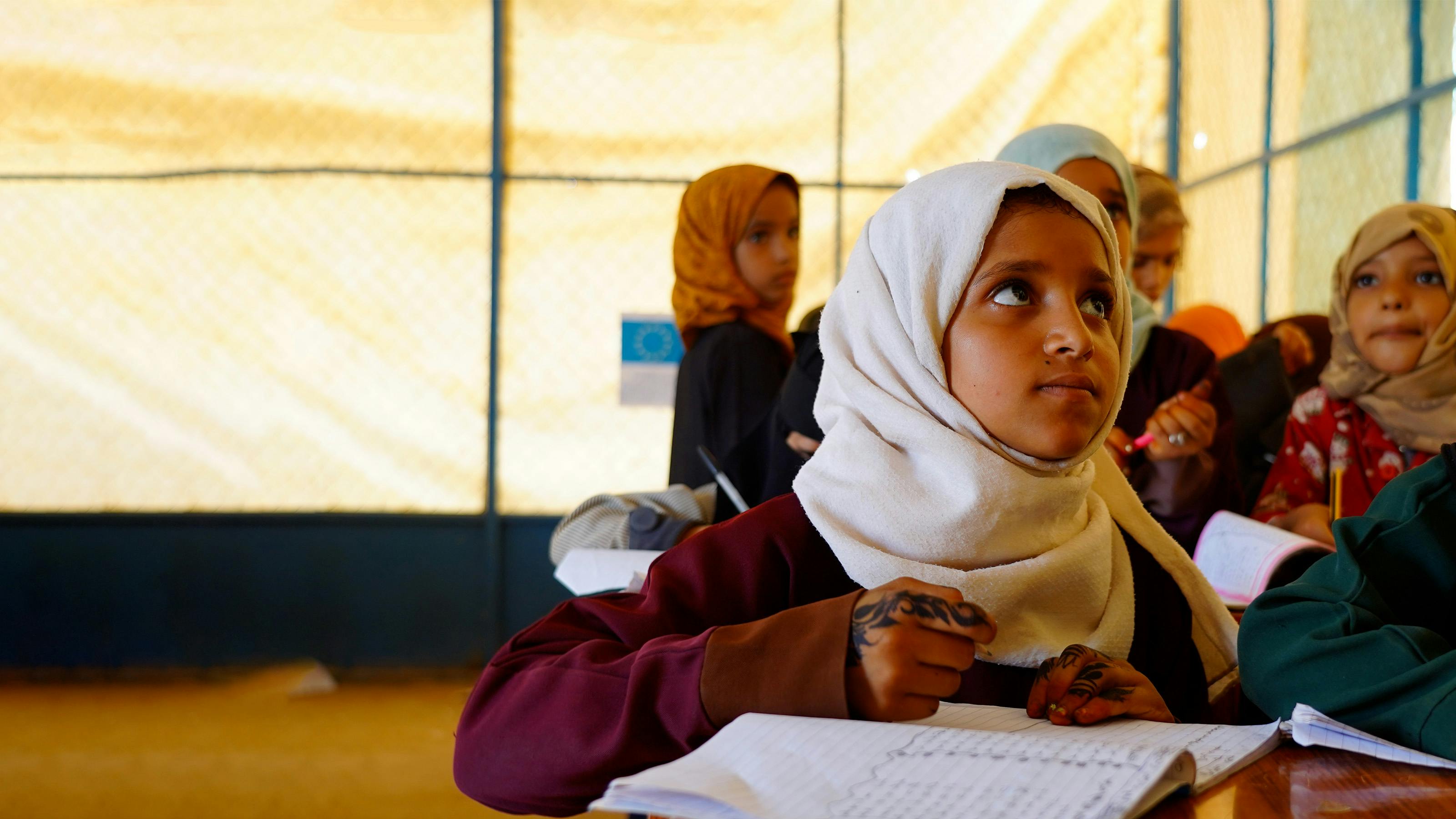 Bambini in classe seguono lezioni di recupero nell'ambito del progetto ECHO, finanziato dall'UNICEF.  Ci troviamo nel campo per sfollati interni di Marib, Yemen.
