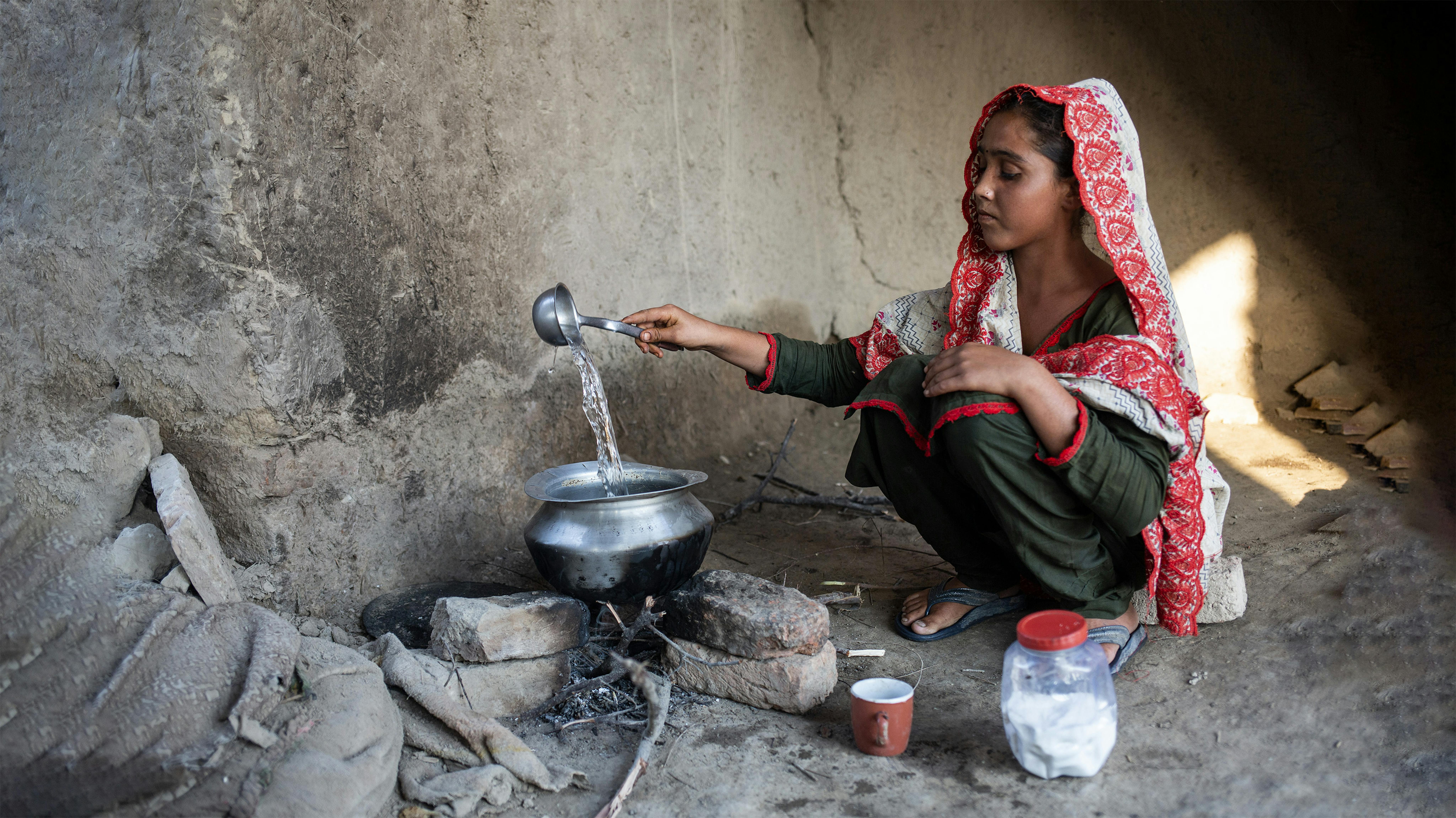 Pakistan, questa ragazza di 15 anni mette a bollire una pentola di acqua. La sua casa è stata distrutta dalle recenti inondazioni, malaria, scabbia e altre malattie dovute dall'inquinamento delle fonti di acqua stanno aumentando tra la popolazione, in particolare tra i bambini