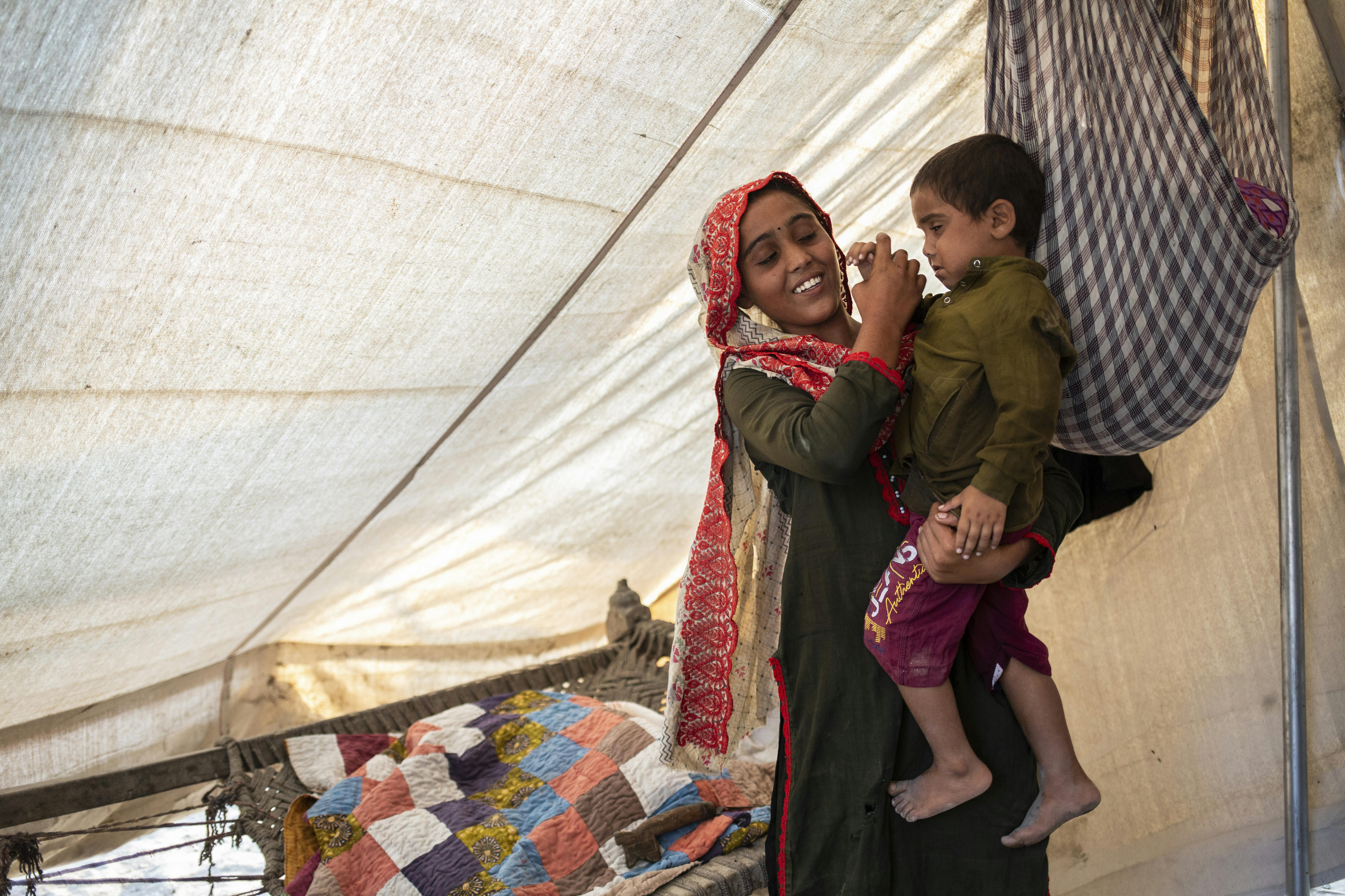 Sugra, 15 anni, tiene in braccio suo fratello, Fayaz di 3, nella tenda in cui si sono rifugiati con il resto della famiglia a seguito dell'alluvione