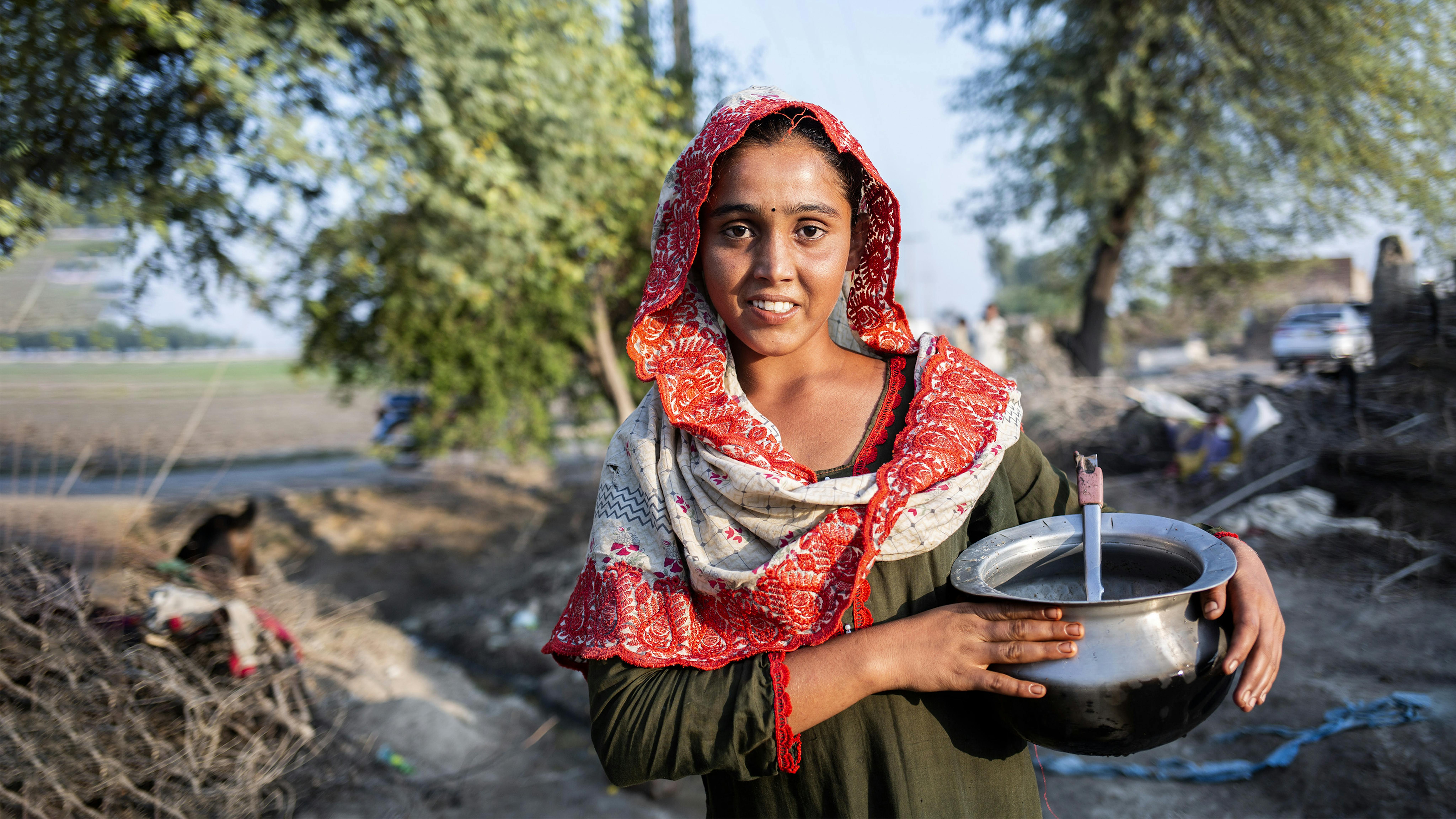 Pakistan, Sugrah, 15 anni, la cui casa è stata distrutta dalle recenti inondazioni, va a prendere l'acqua per portarla nel rifugio in cui vive con la sua famiglia