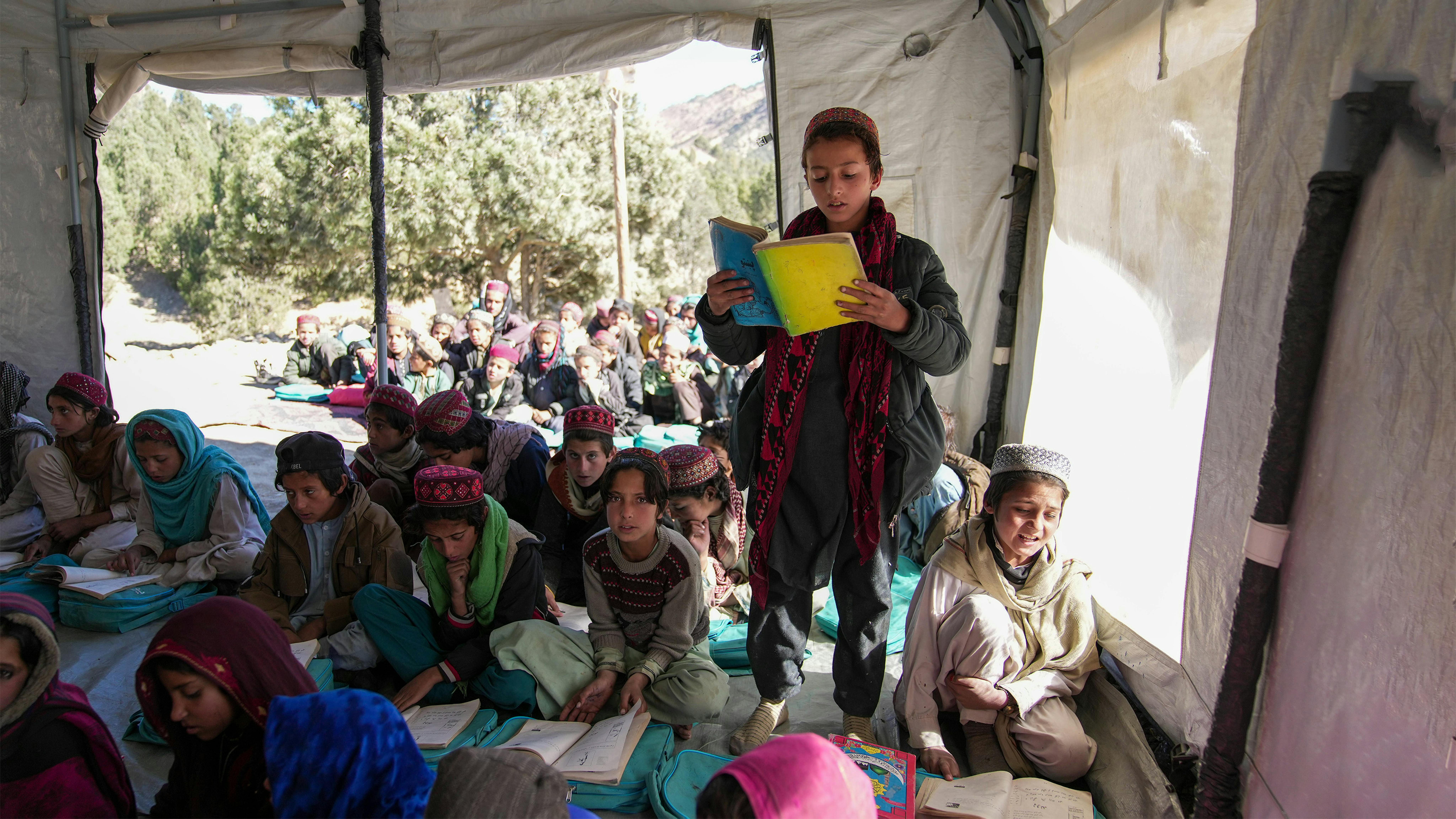 Afghanistan, un ragazzo legge dal suo libroin una classe di educazione comunitaria sostenuta dall'UNICEF nel distretto di Spera