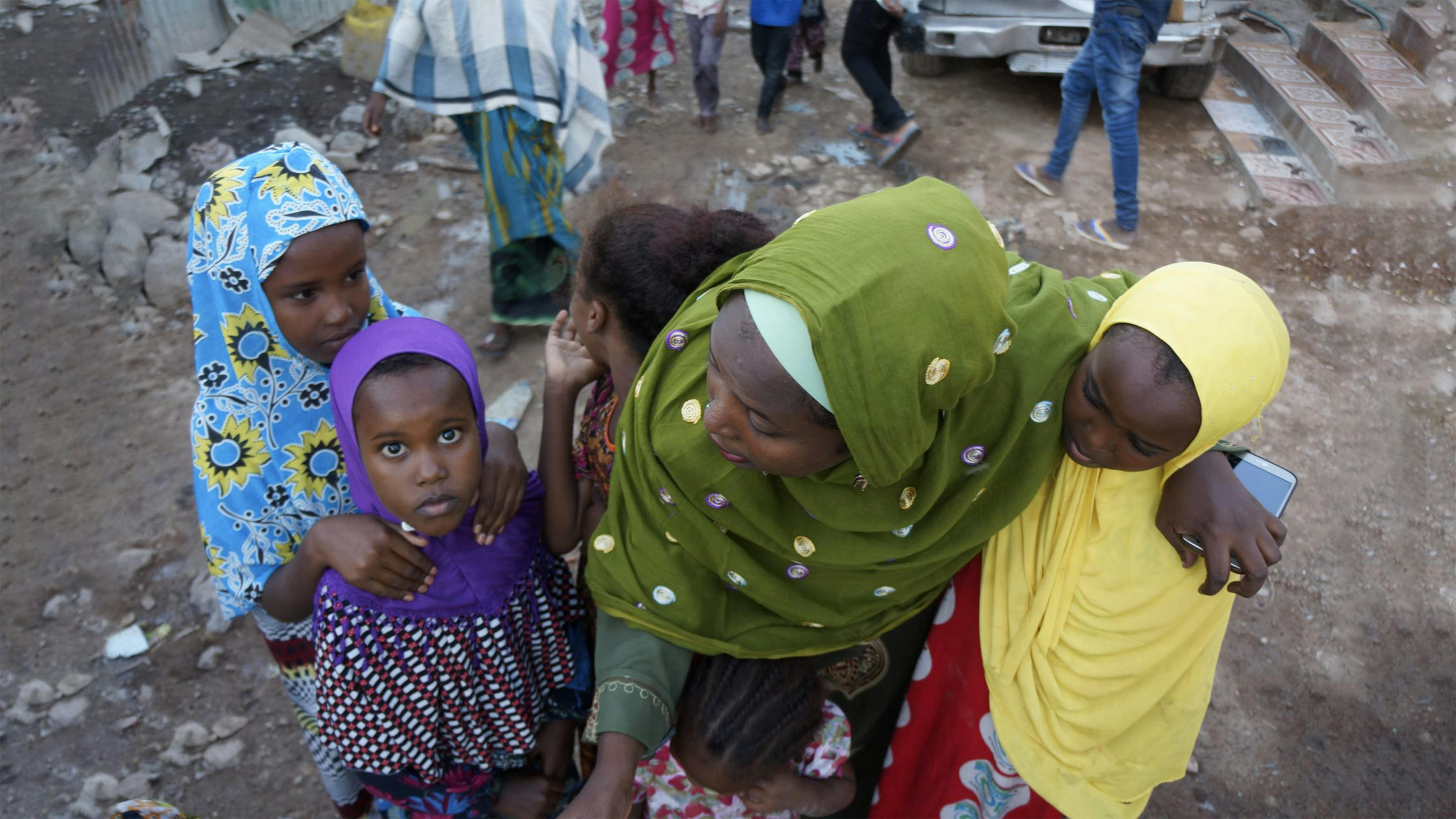Mariam, vittima di FGM, abbraccia le bambine fuori dalla sua casa a Babala, in Gibuti