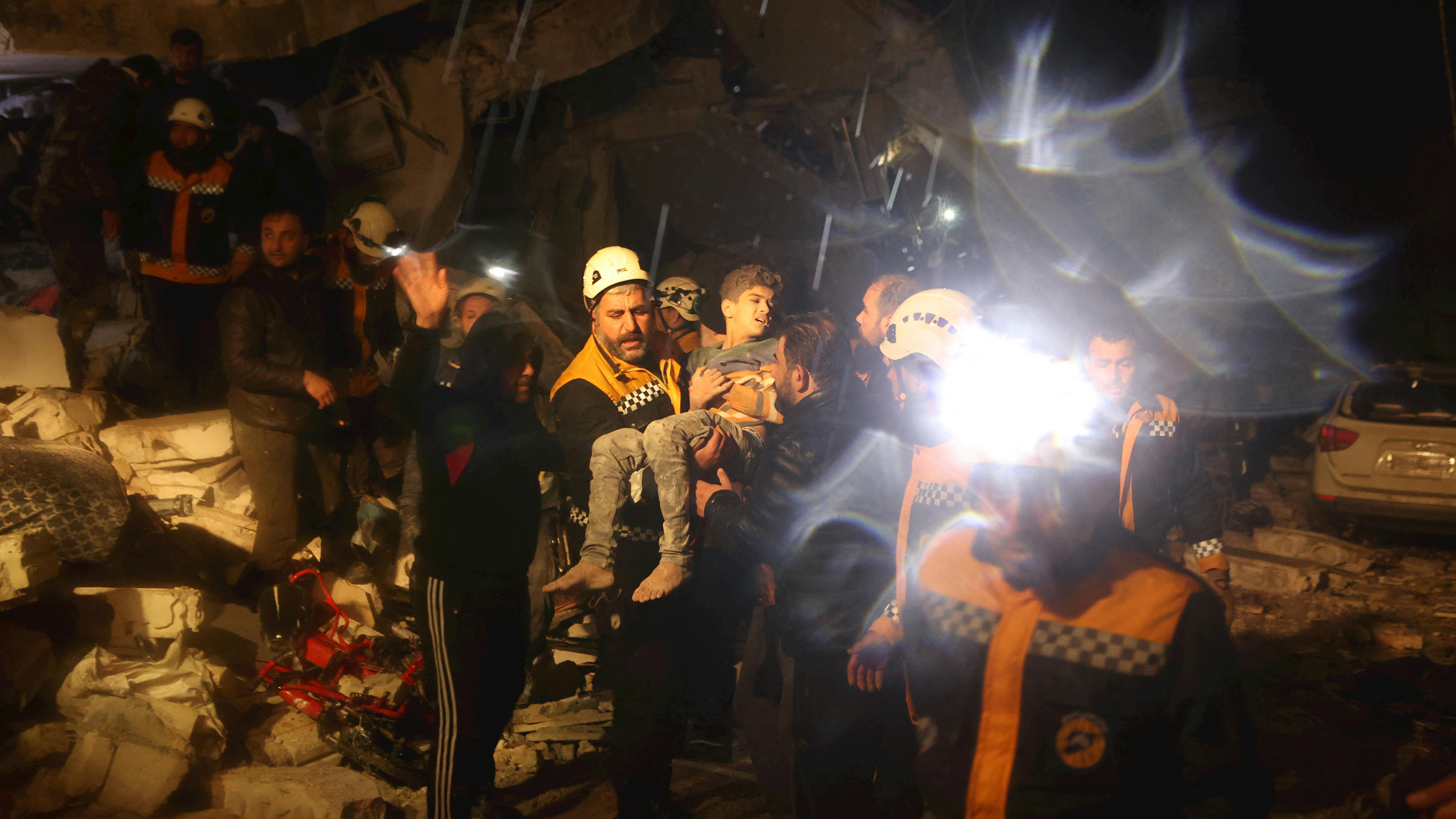 Siria - , i soccorritori trasportano un ragazzo che hanno recuperato dalle macerie di un edificio dopo un terremoto a Dana, Idlib, © UNICEF/UN0777952/Watad/AFP
