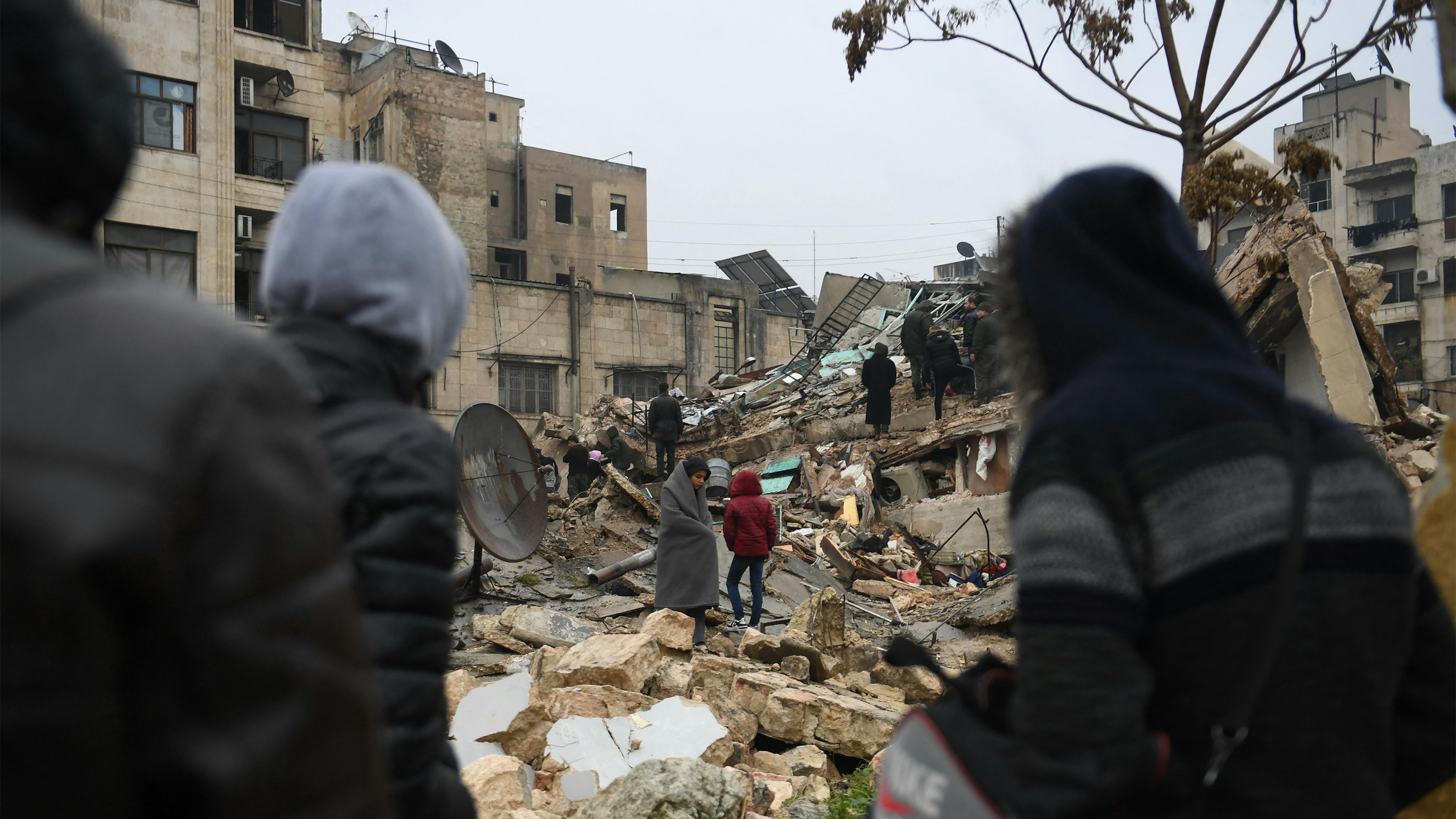 Siria - persone si radunano intorno agli edifici crollati mentre le squadre di soccorso cercano i sopravvissuti a seguito del terremoto nella città di Aleppo © UNICEF/UN0777950/AFP