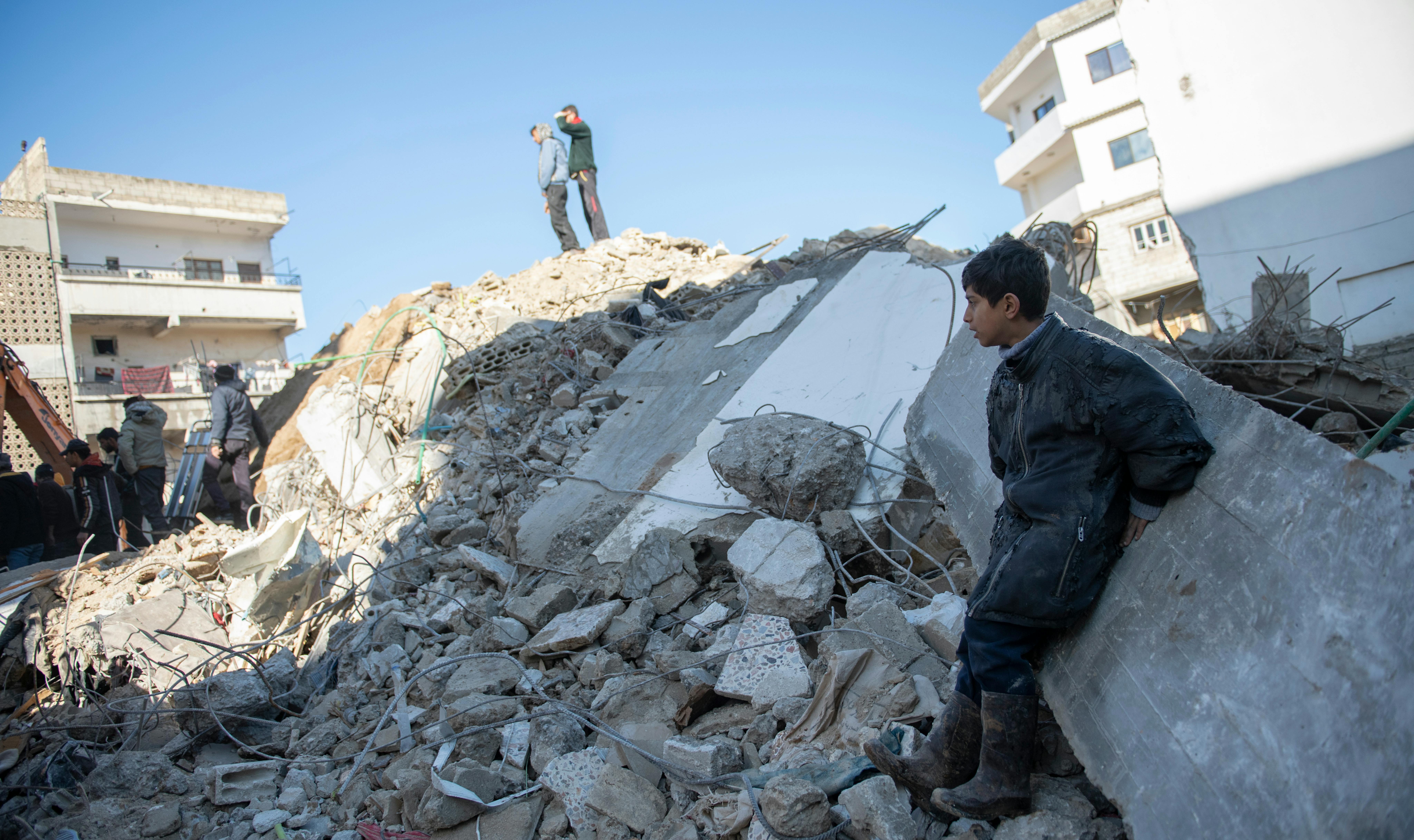 Siria - Un ragazzo nella città di Jableh, osserva i lavori di scavo dopo il terremoto che ha colpito la sua città.