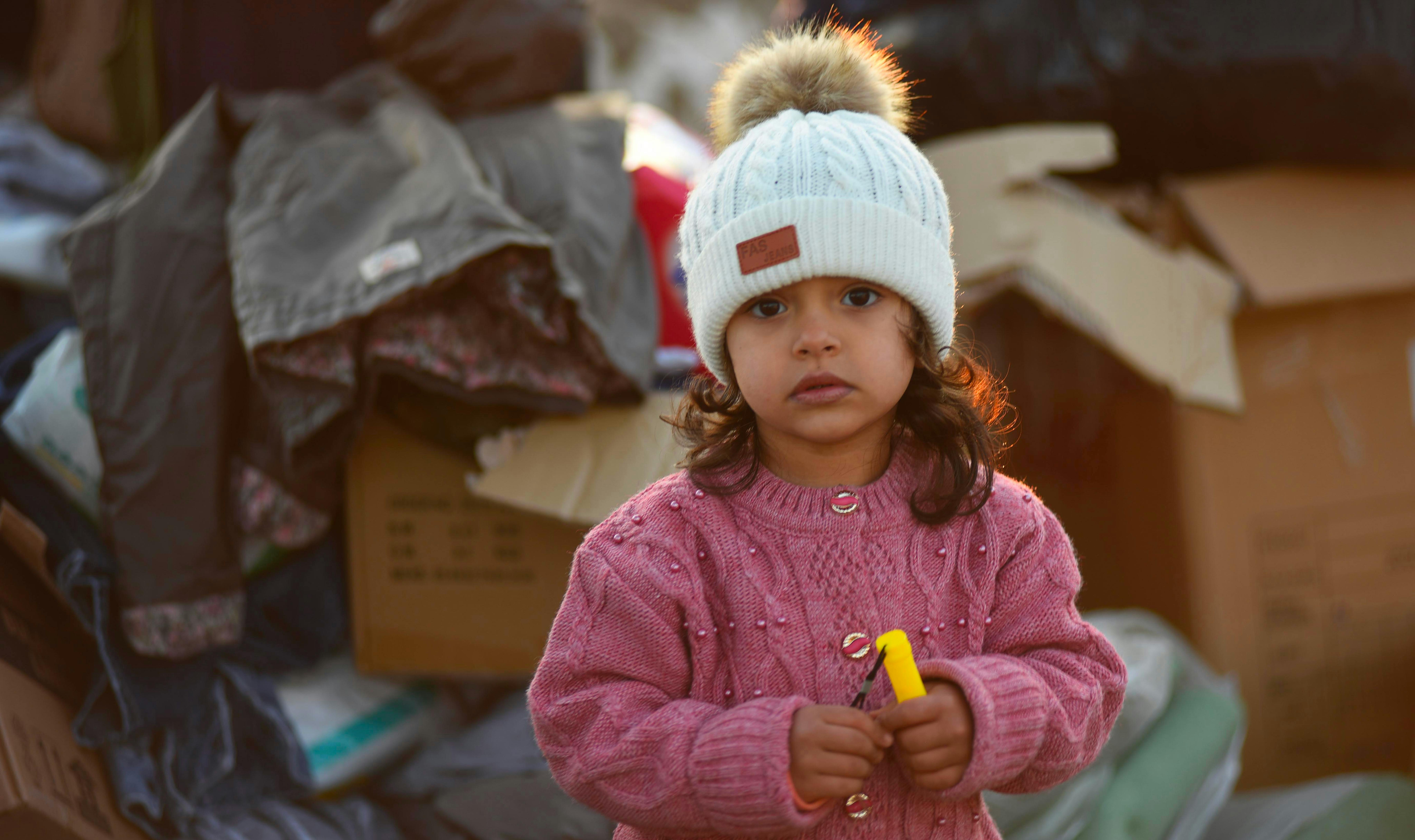 Turchia - una bambina con alle spalle gi aiuti inviati ai sopravvissuti del terremoto a Kahramanmaraş,