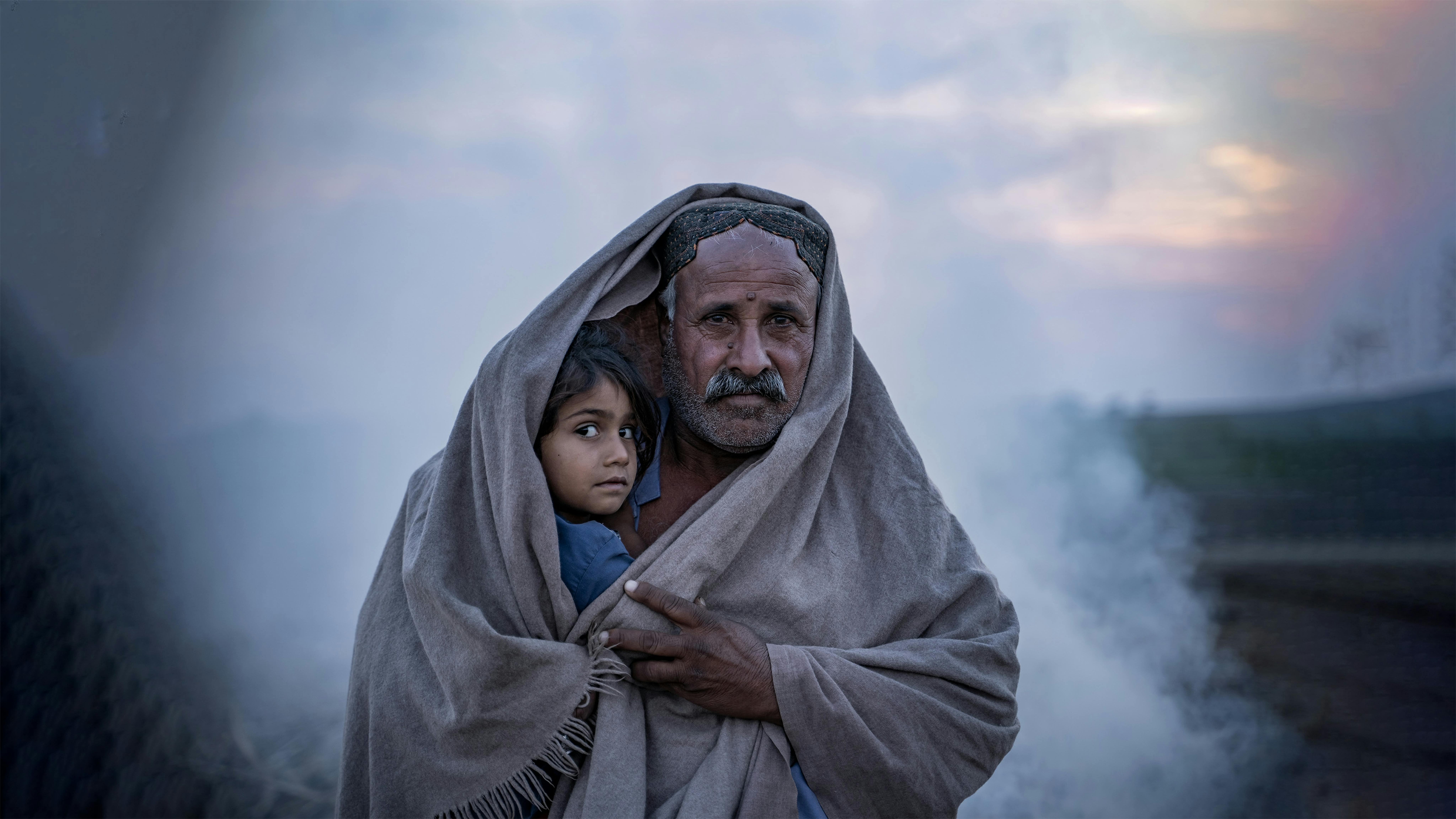 Pakistan: Hasol Khan copre sé stesso e sua figlia Nargis di 4 anni con uno scialle fuori dalla sua tenda nel villaggio di Zangi Brohi, distretto di Dadu, Sindh.