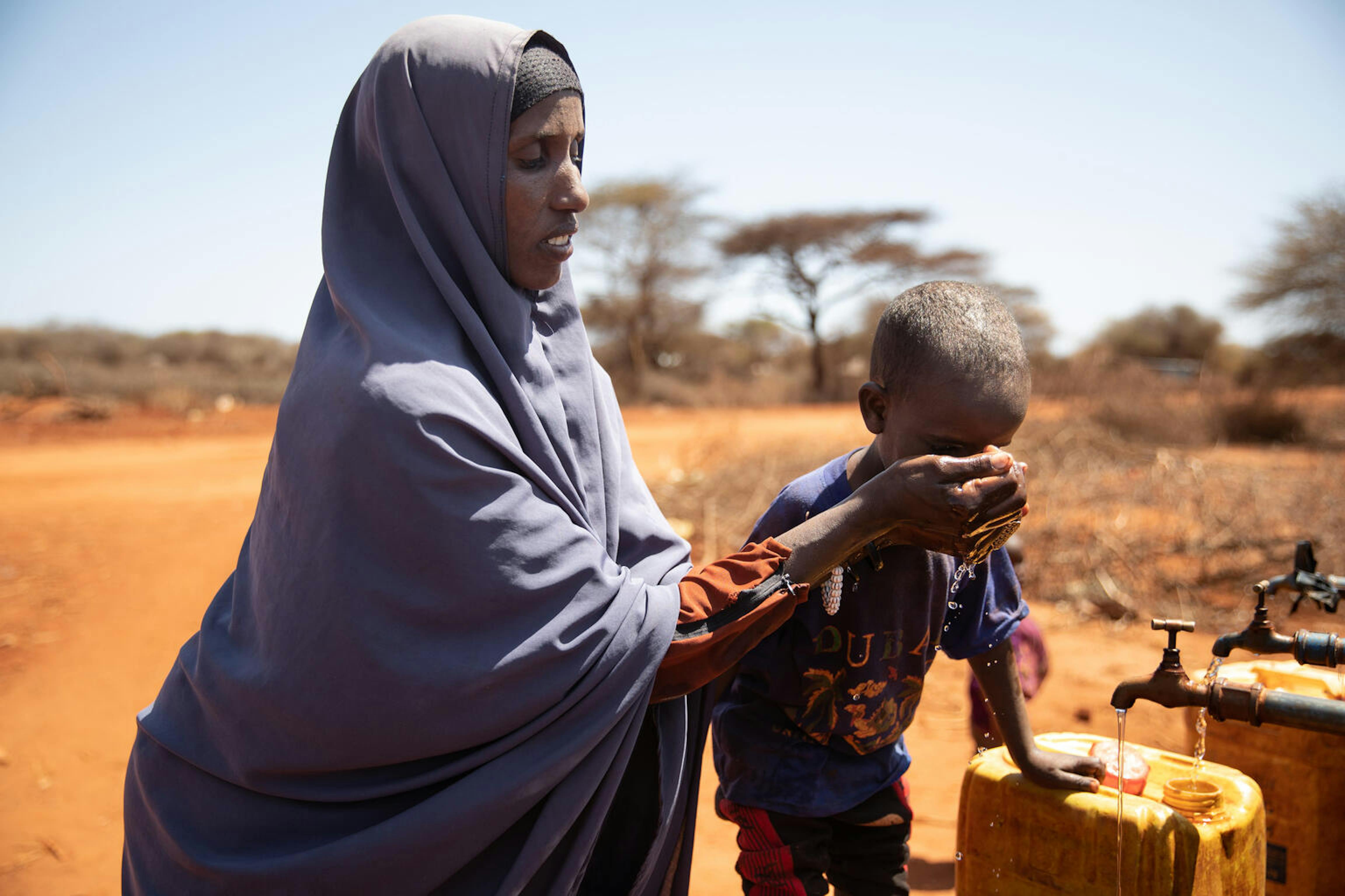 Etiopia. Hadija Khulla, madre di sette figli, beve acqua dopo aver riempito le sue taniche. Per Hadija, l'acqua è tutto. 