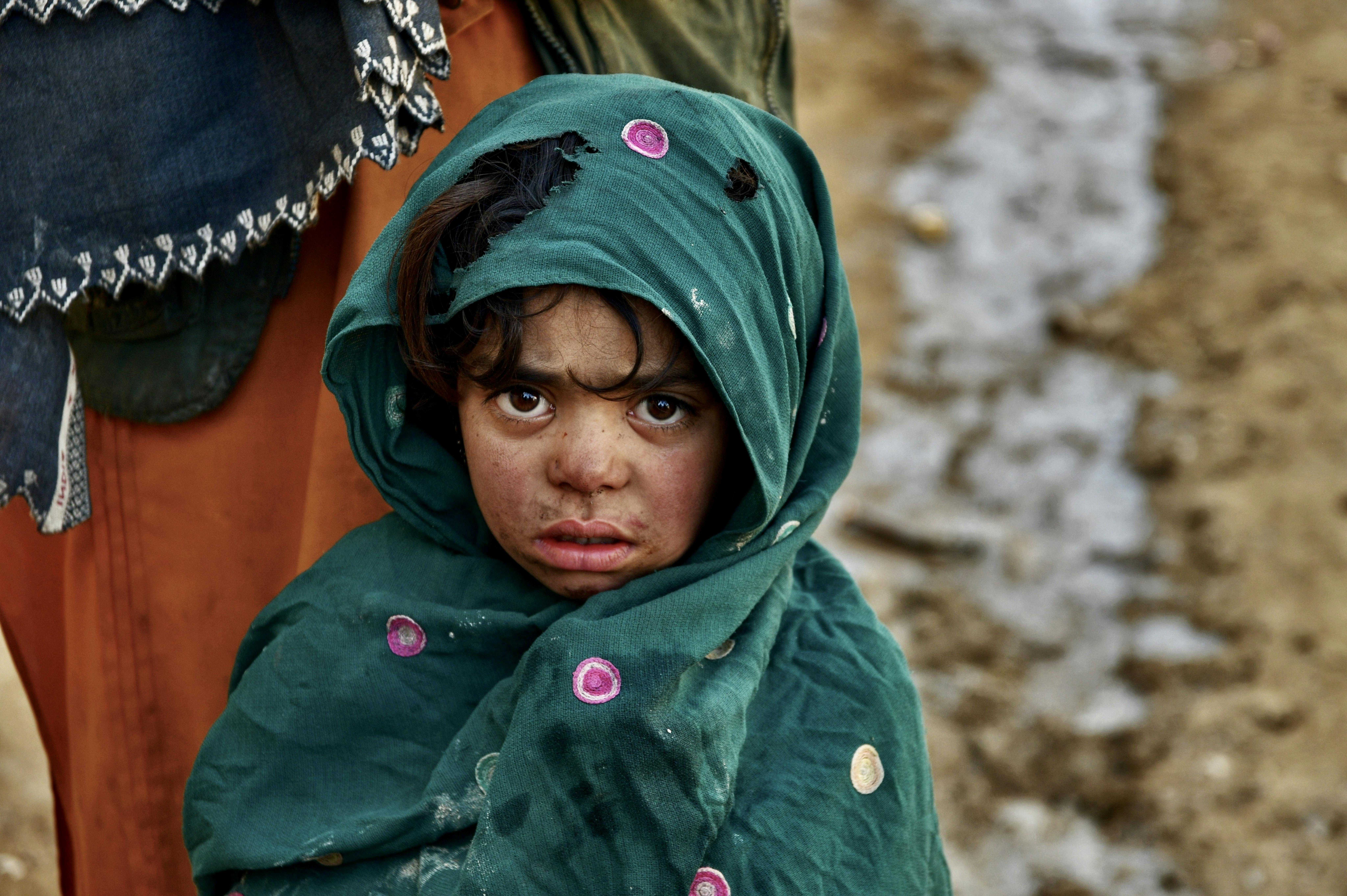 Afghanistan, una bambina guarda in camera. La foto fa parte della raccolta di scatti esposti al MAXXI fino al 5 marzo nel contesto della mostra "Can you smile for me? L'infanzia sperduta"
