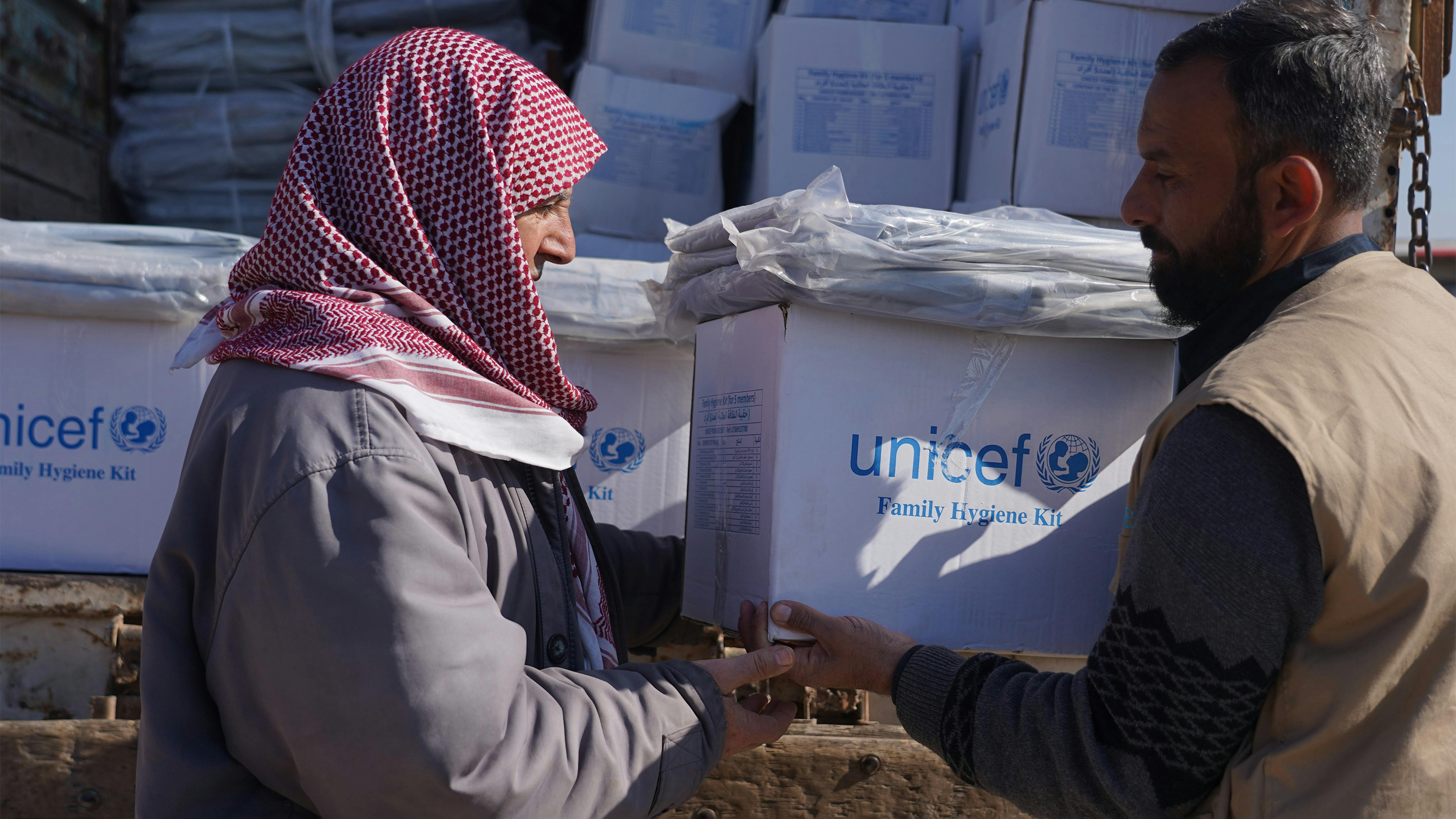 Siria - un uomo riceve un kit per l'igiene dal partner dell'UNICEF Ihsan nel campo di Al-Kamuna