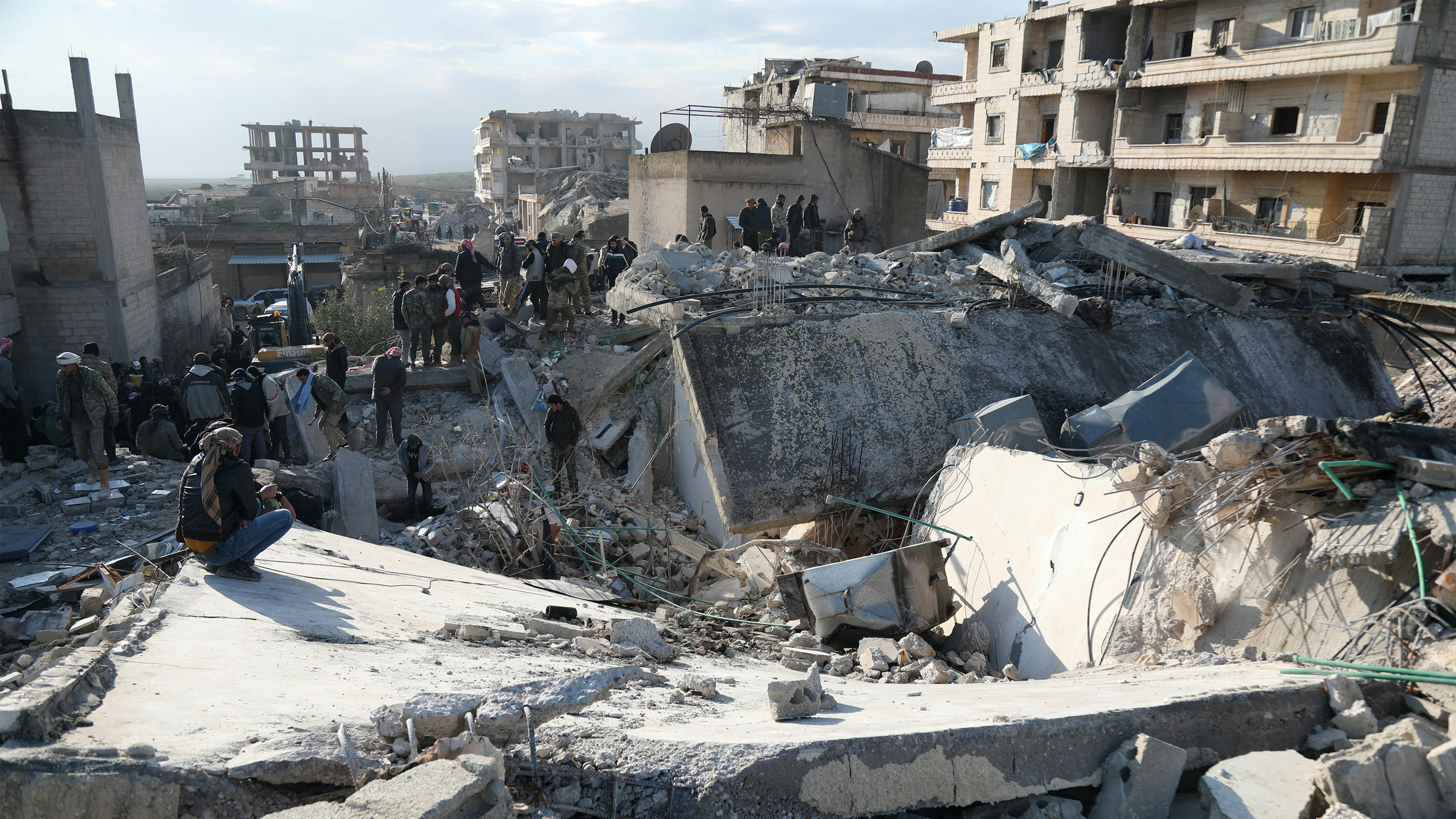 Siria - residenti e squadre di soccorso cercano sopravvissuti sotto le macerie di un edificio crollato a Jandairis