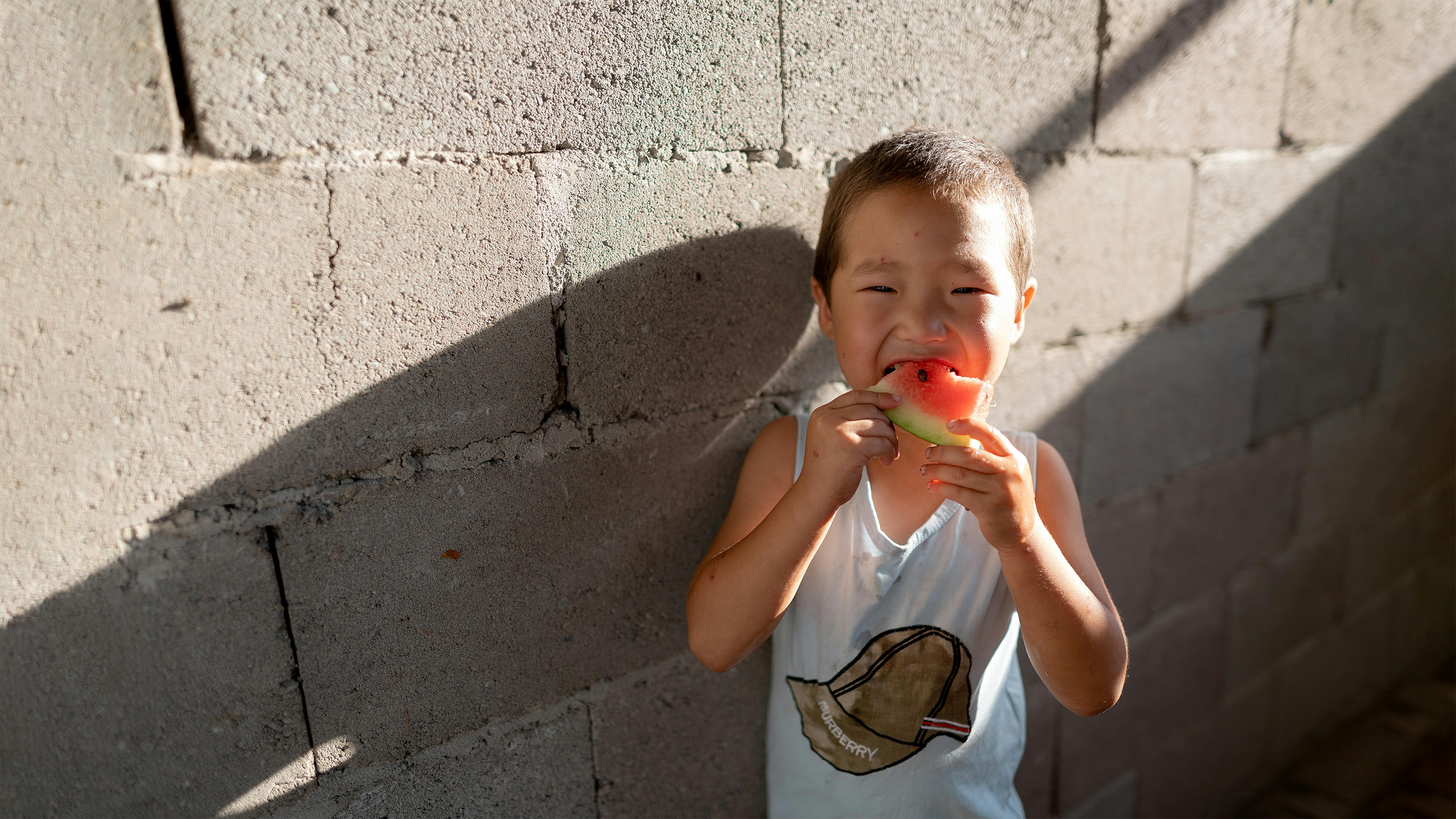 Kyrgyzstan - Azamat, 5 anni, mangia anguria a casa nel villaggio di Kurshab,