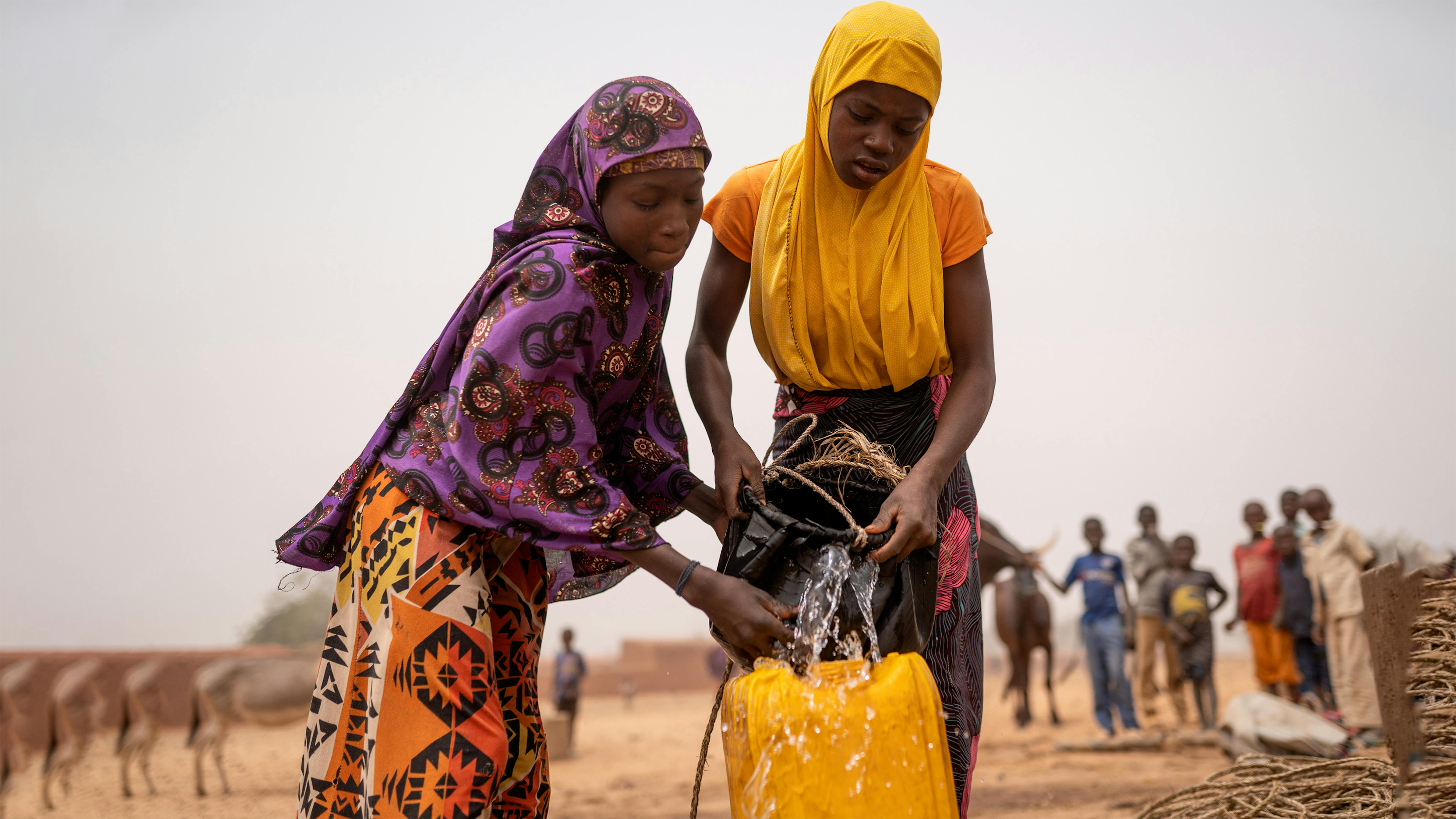 Niger Roukaya (15, a destra) e la sua amica Jamila (13, a sinistra) trascorrono diverse ore al giorno per raccogliere l'acqua per le loro famiglie